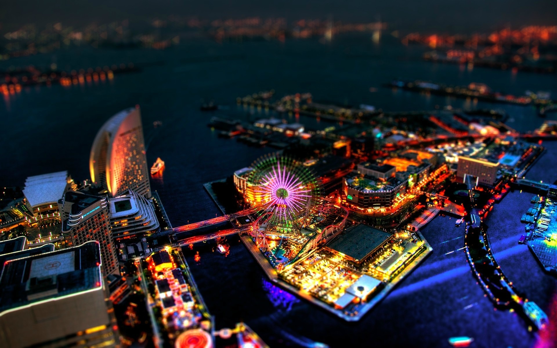 Cityscape at night with Ferris wheel and illuminated buildings HD Wallpaper