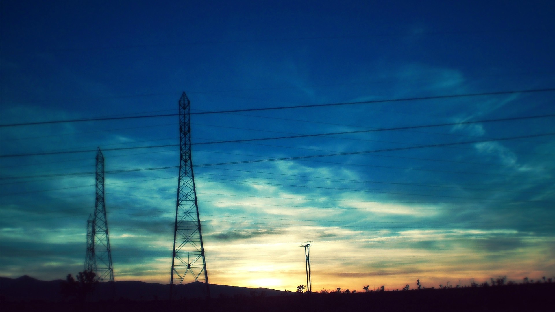 Electricity pylons against a sunset sky HD Wallpaper