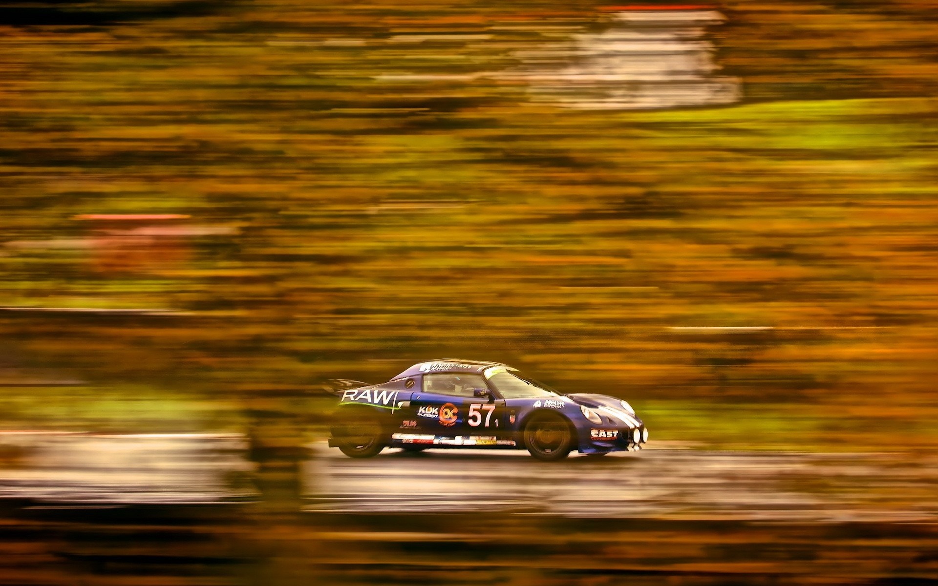 Blue racing car with number 57 on a blurred track HD Wallpaper
