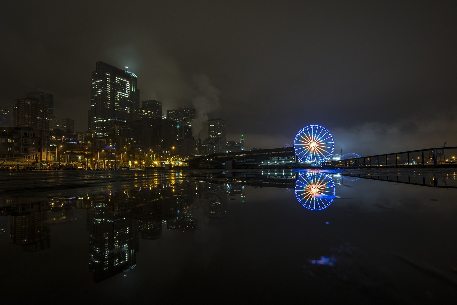 Cityscape at night with Ferris wheel and reflections HD Wallpaper