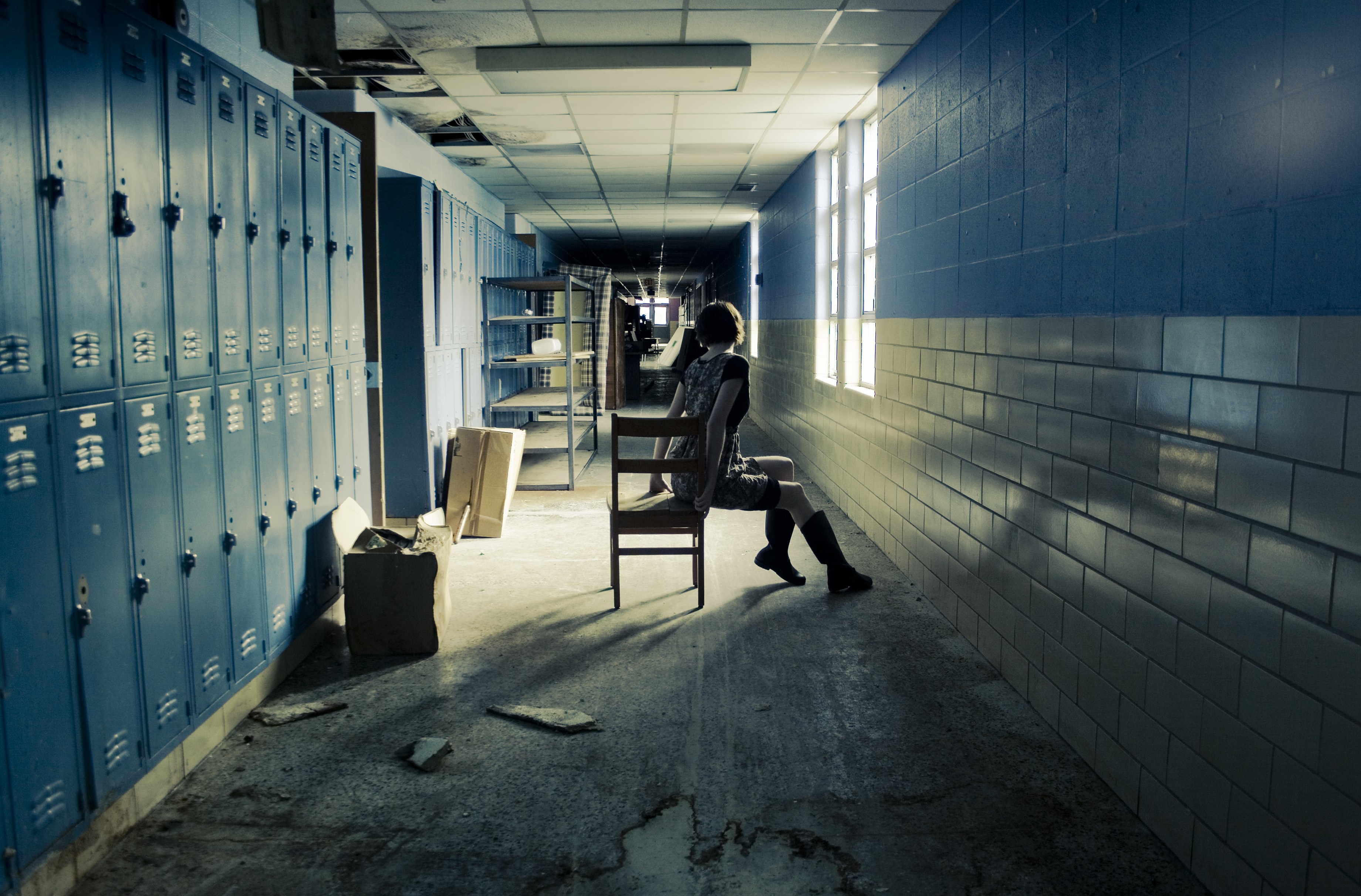 Woman sitting on a chair in an abandoned hallway HD Wallpaper