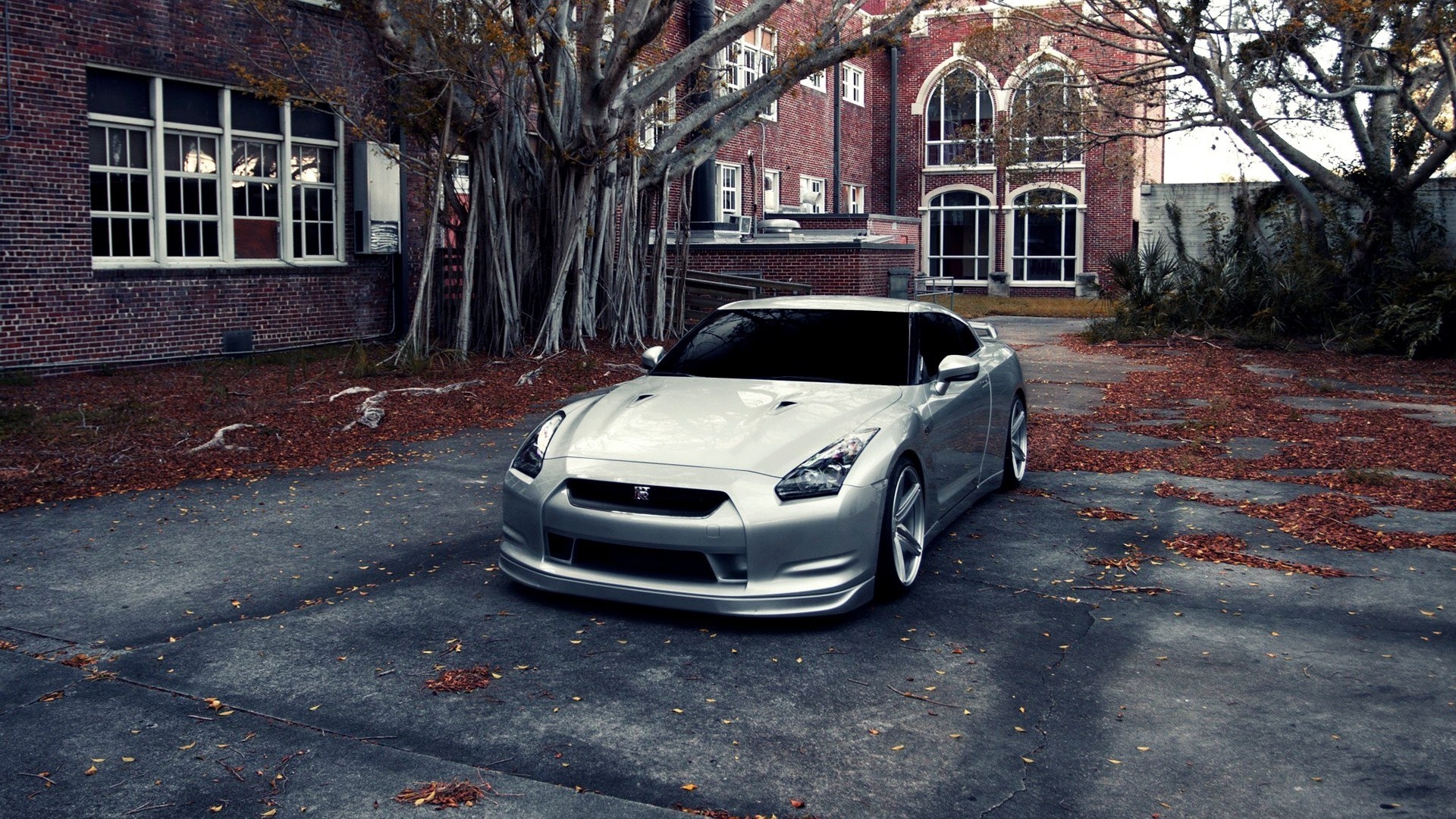 Silver Nissan GT-R parked in front of a brick building HD Wallpaper
