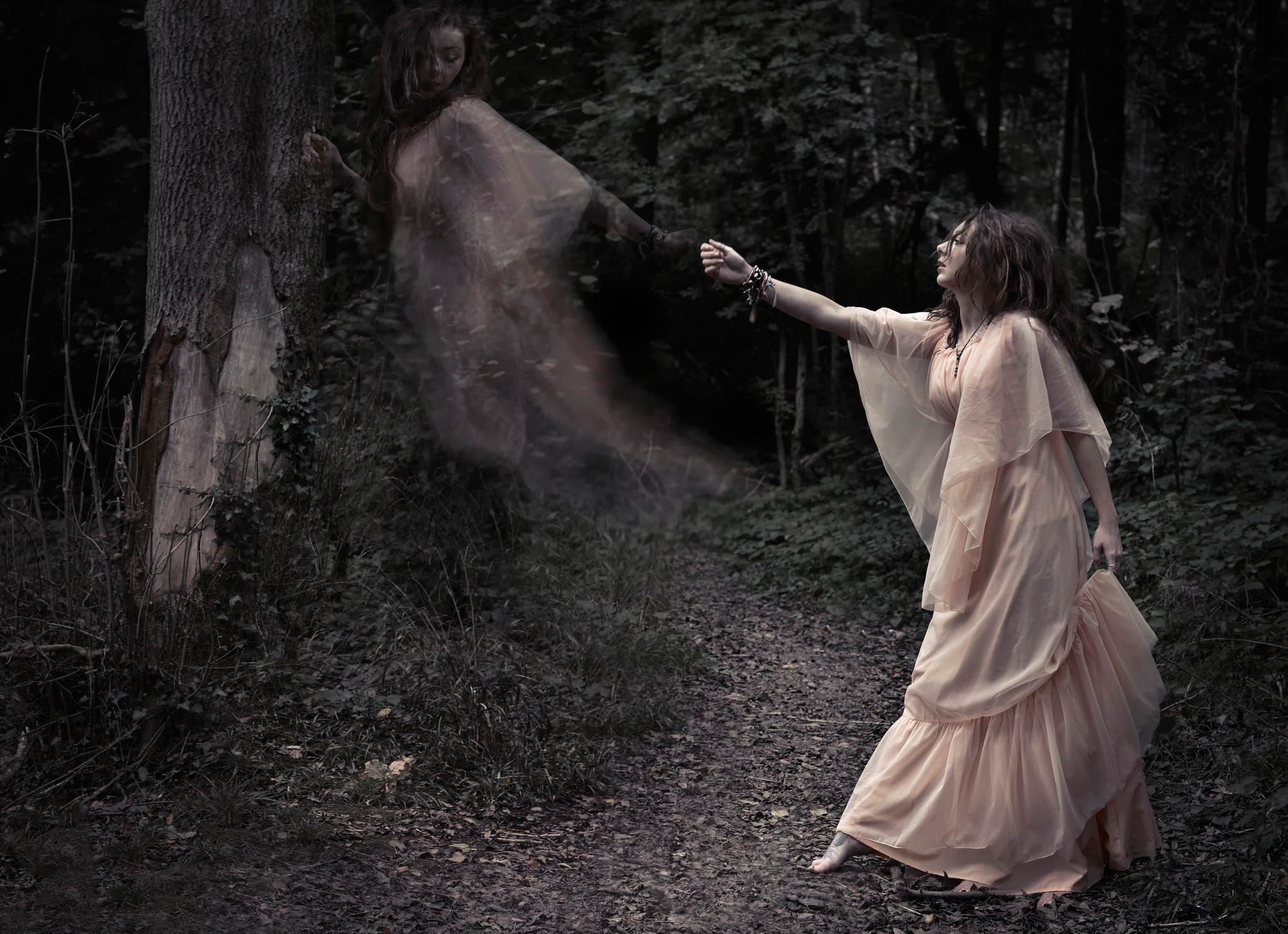 Woman reaching for a ghost in a dark forest HD Wallpaper