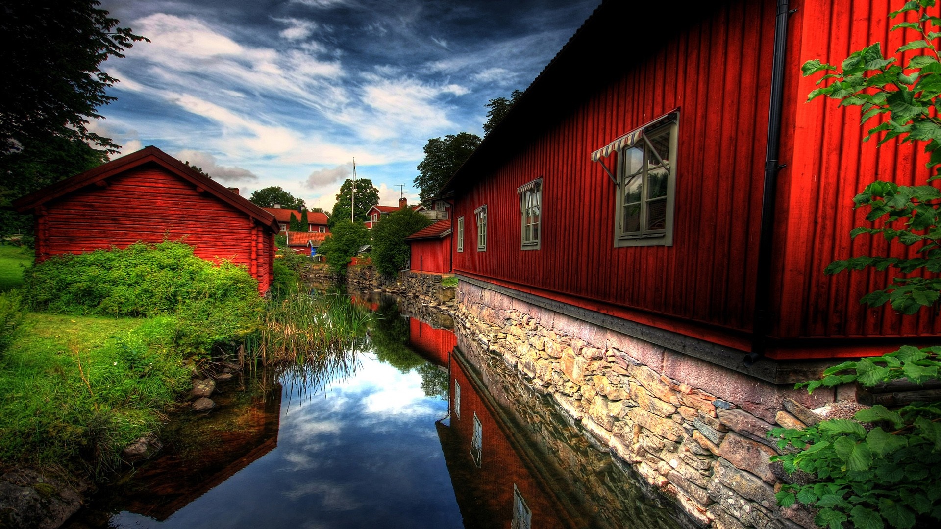 Red wooden houses by a canal in Sweden HD Wallpaper