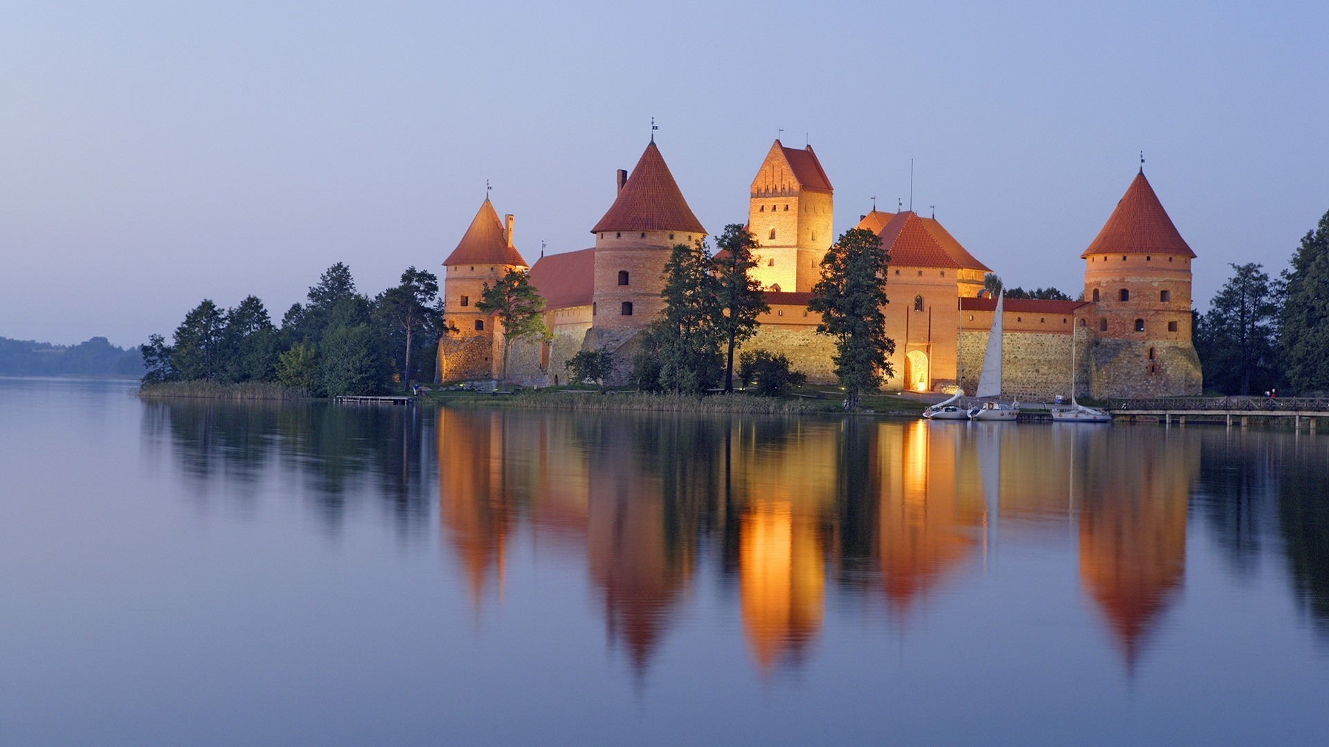 Trakai Island Castle reflected in the water at dusk HD Wallpaper