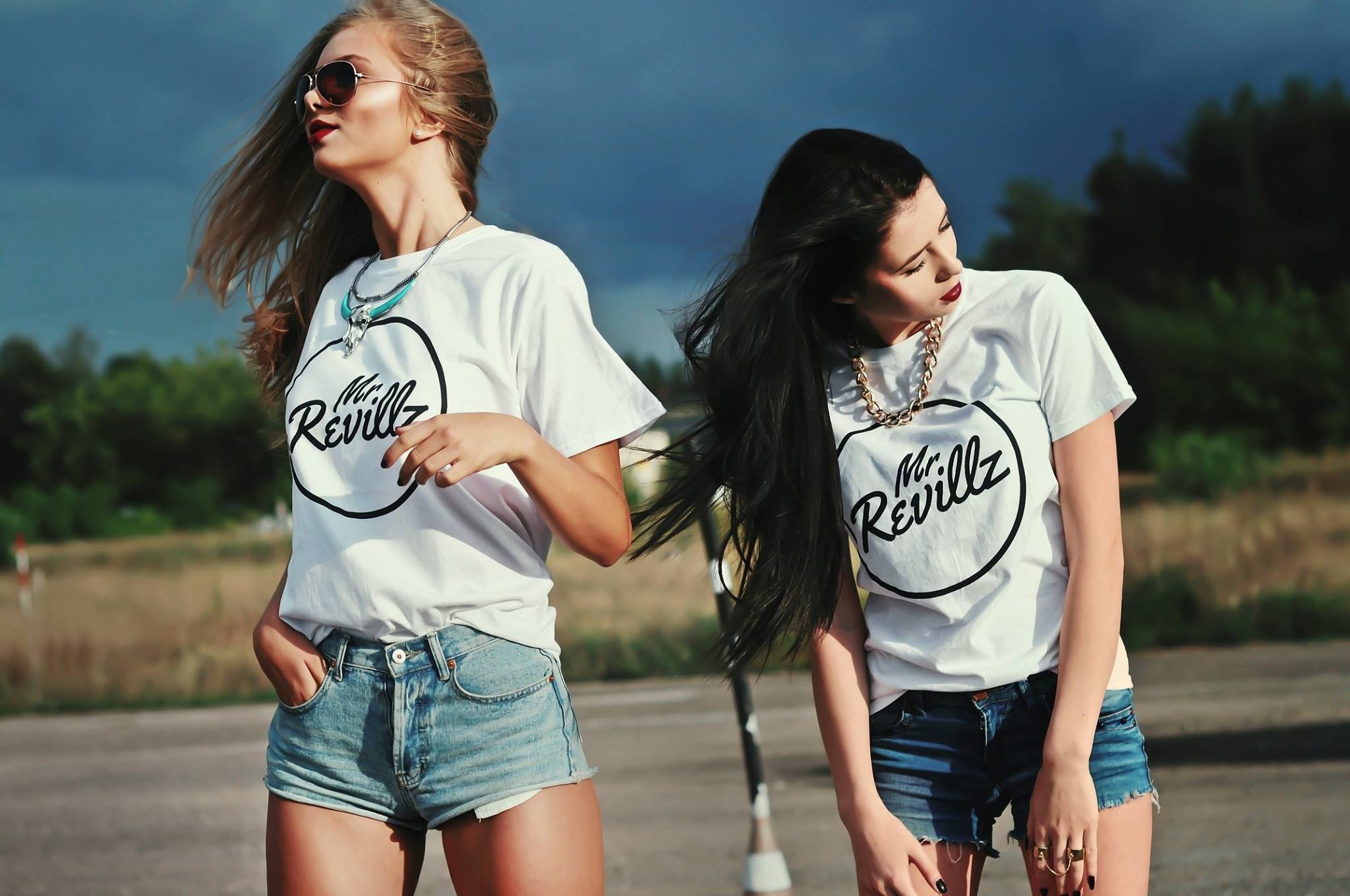 Two women wearing t-shirts and jean shorts outdoors HD Wallpaper