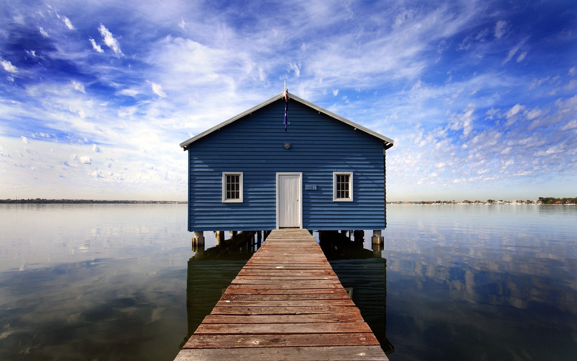 Blue house on stilts over water with wooden pier HD Wallpaper