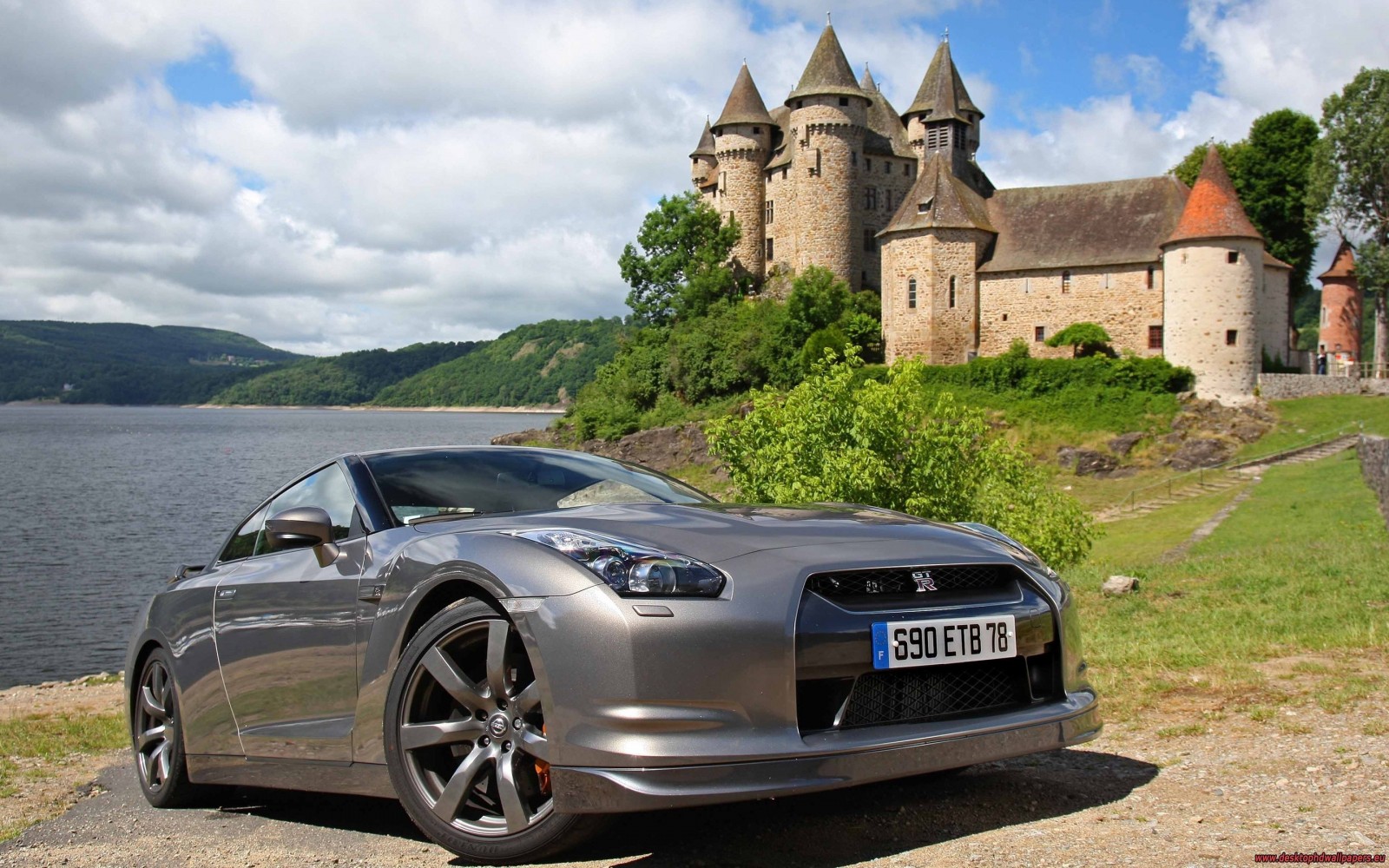 Nissan GT-R parked near a castle by a lake HD Wallpaper