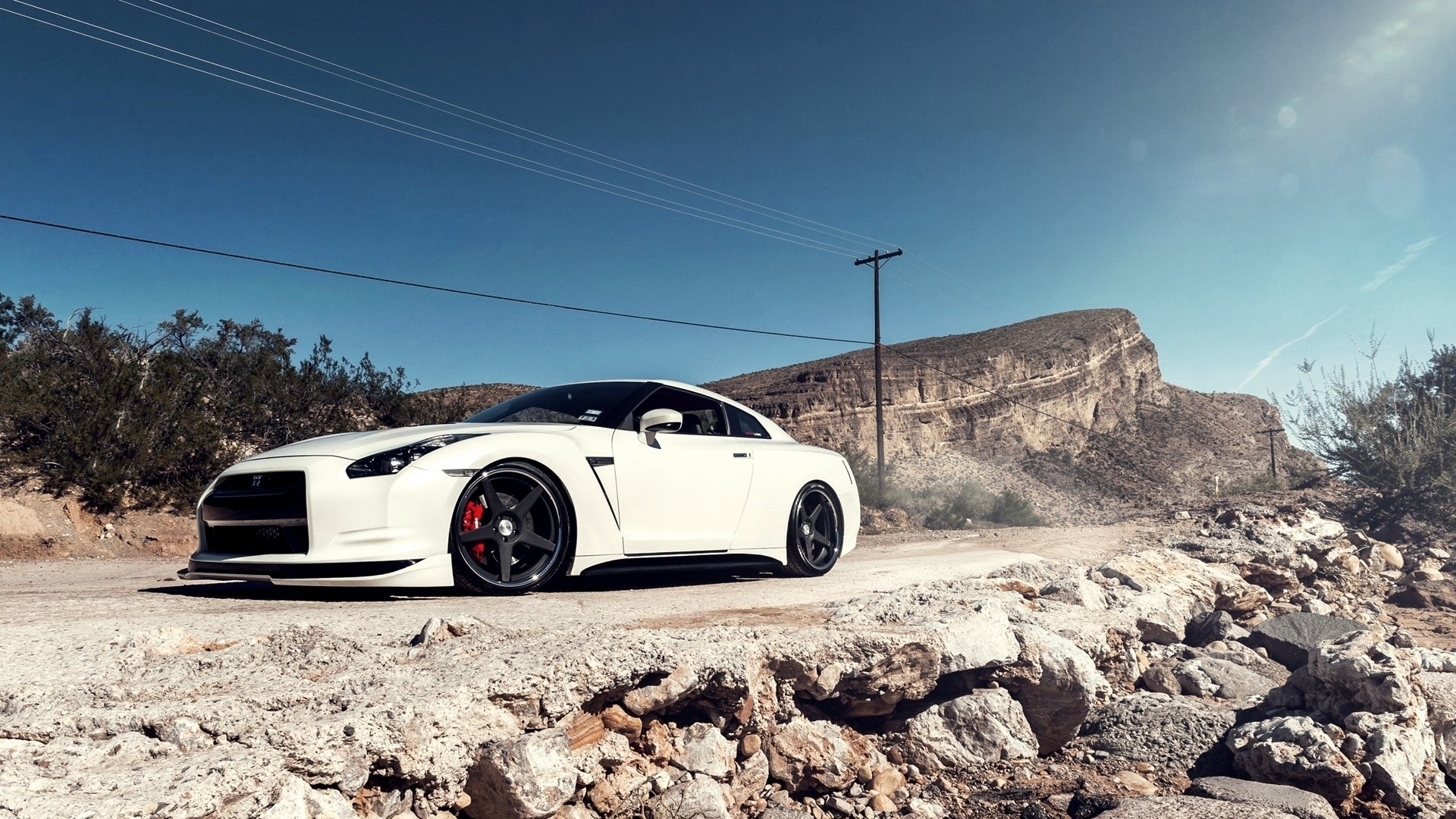 White Nissan GT-R on a dirt road with mountains HD Wallpaper