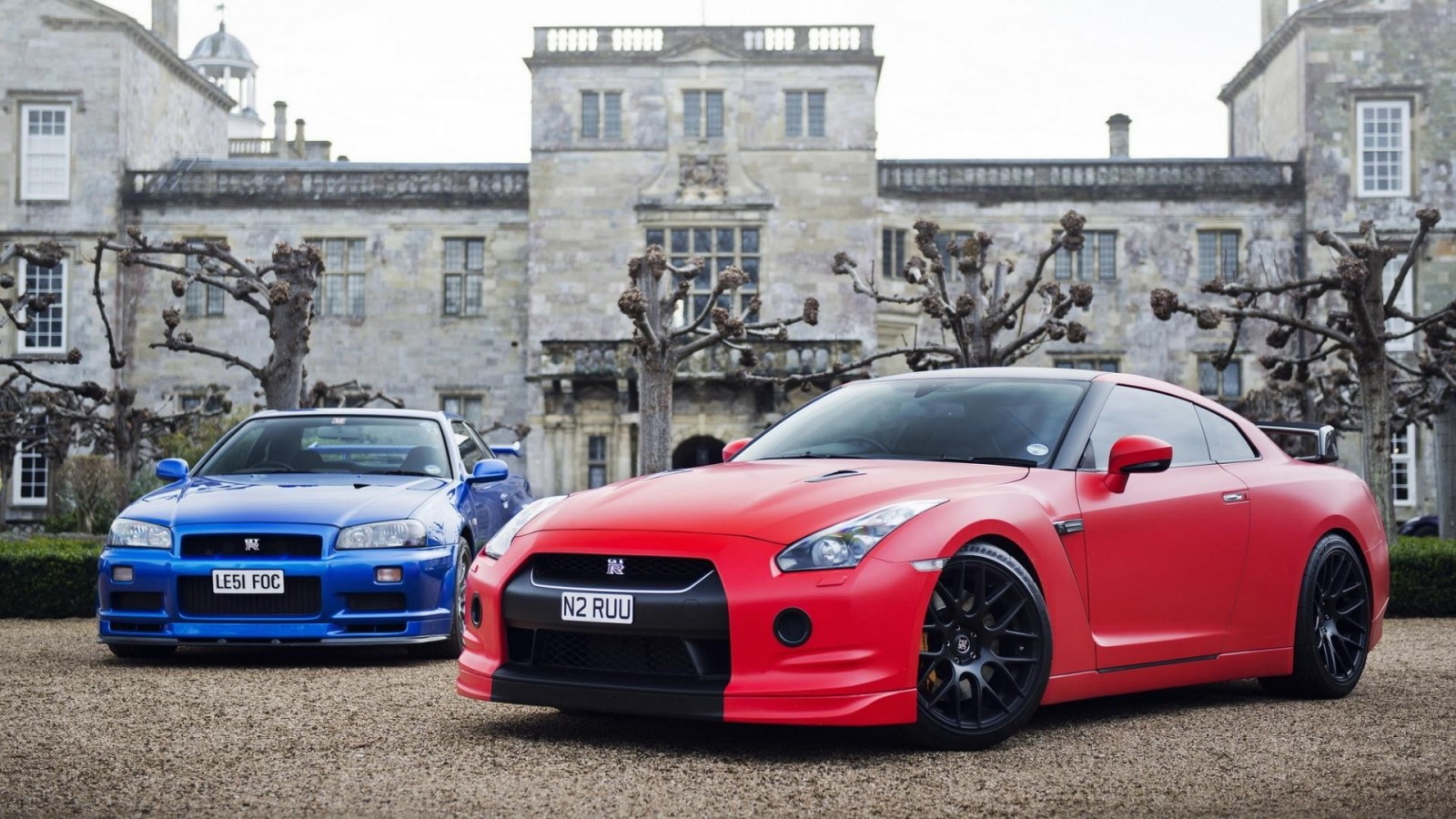 Two Nissan GT-R cars in front of a manor HD Wallpaper