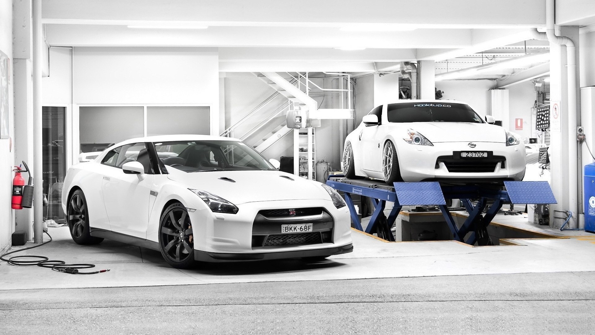 Two white Nissan sports cars in a garage HD Wallpaper