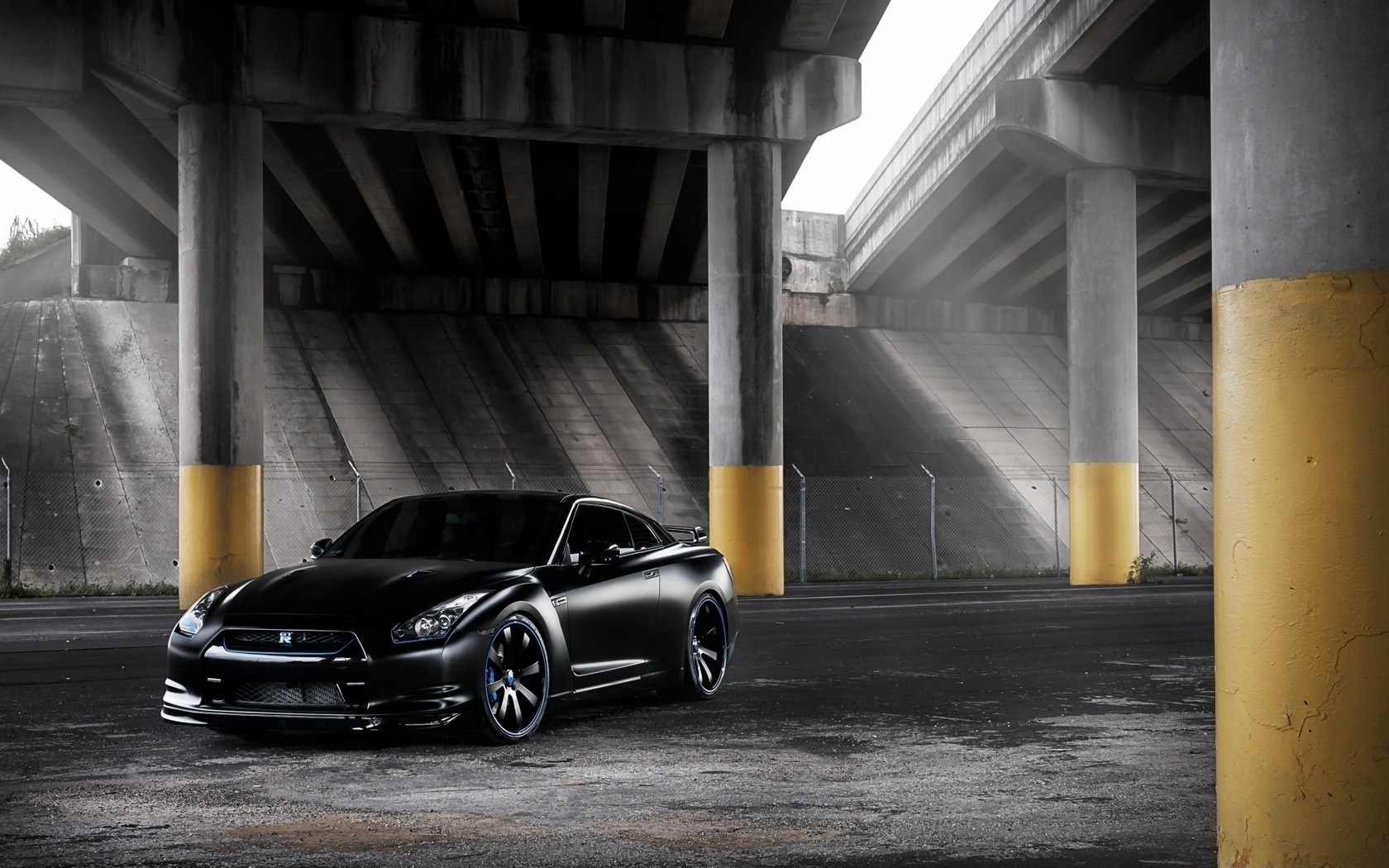 Black Nissan GT-R parked under a concrete overpass HD Wallpaper