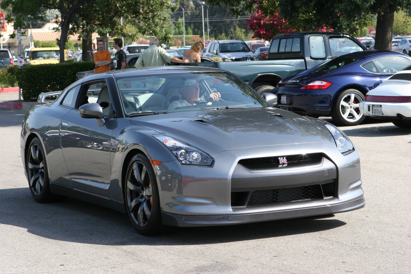 Nissan GT-R parked in a lot with people HD Wallpaper