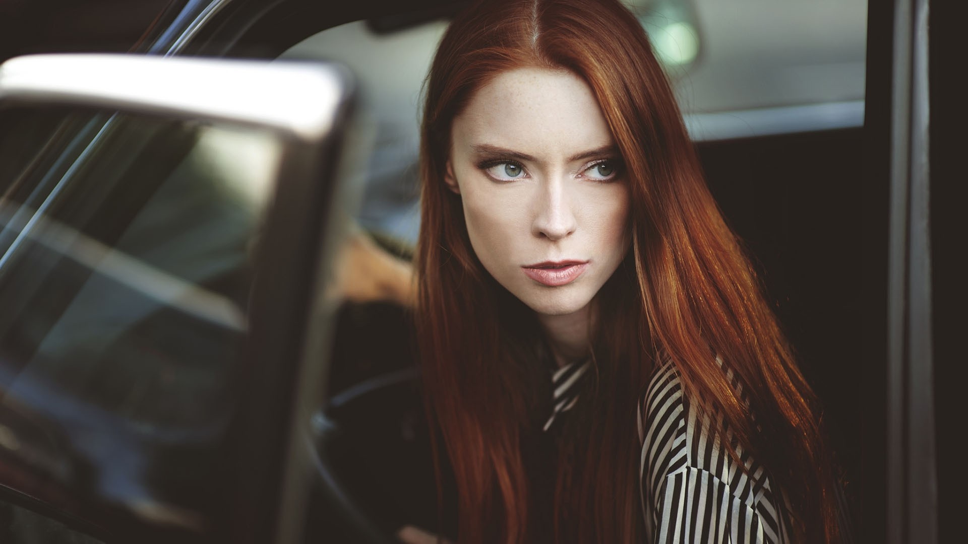 Redhead woman with long hair in a car HD Wallpaper
