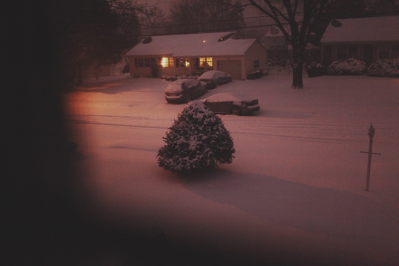 Snowy suburban street at night with cars and house HD Wallpaper