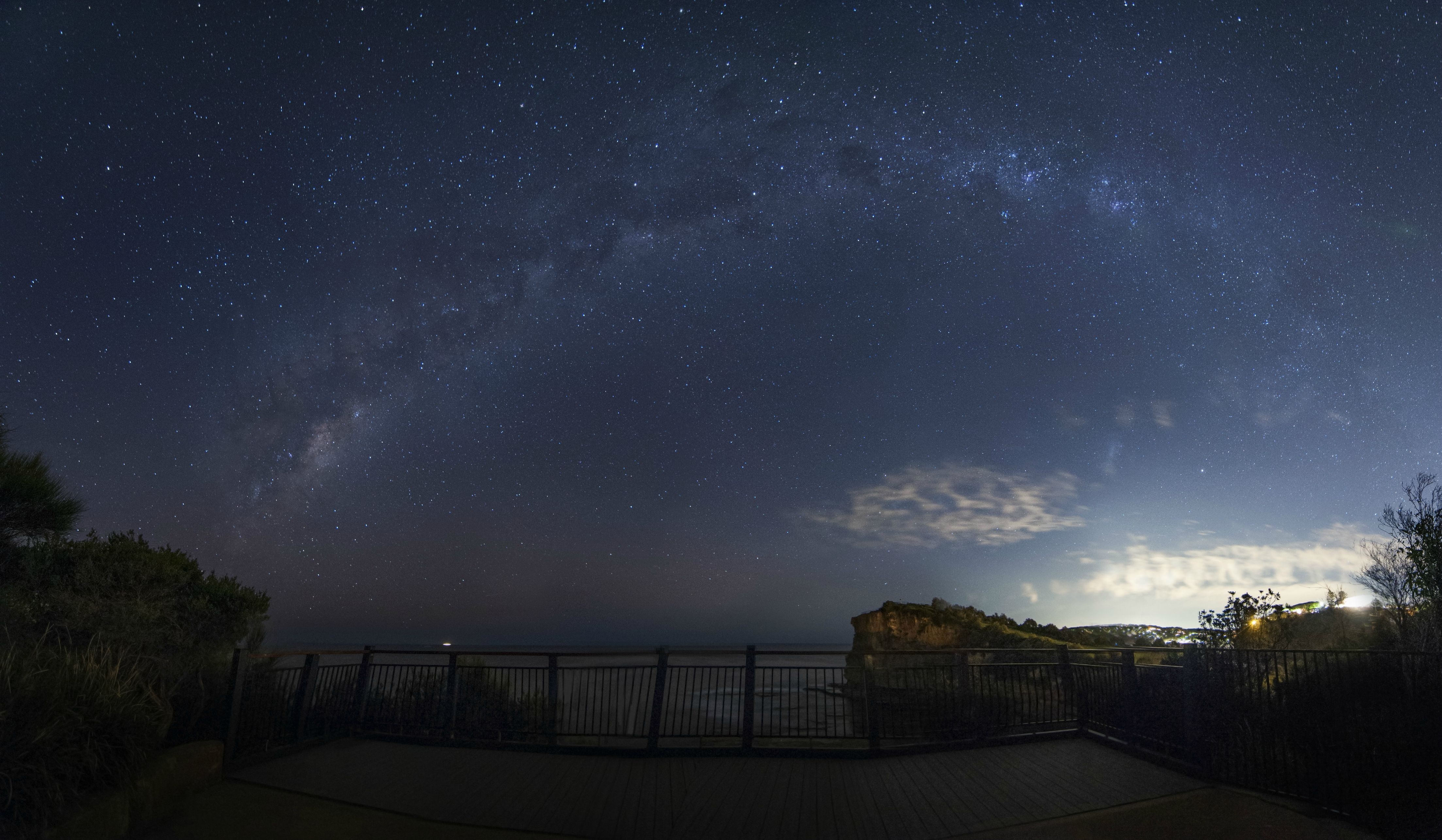 Milky Way galaxy over a coastal viewpoint at night HD Wallpaper