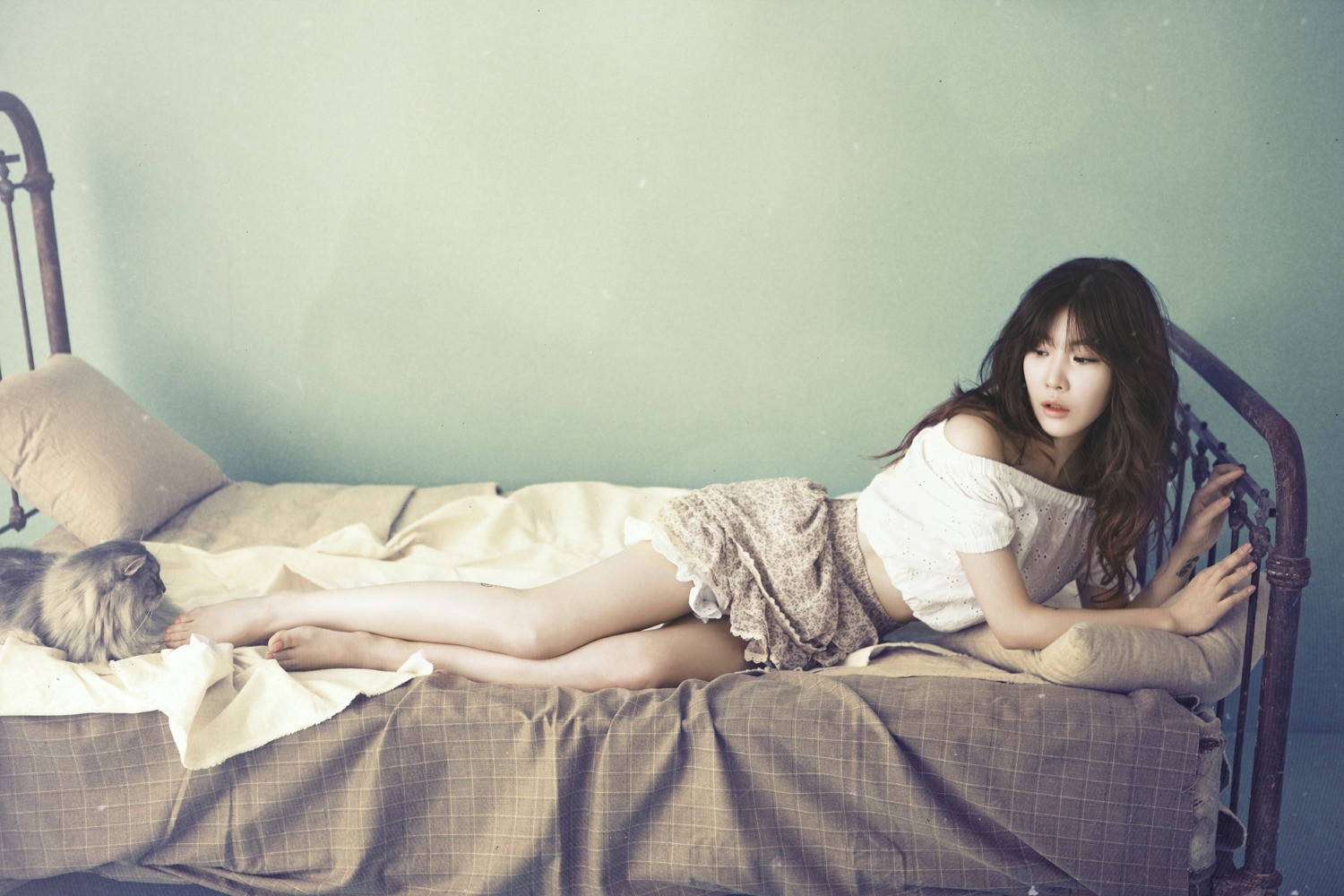 Korean girl with long hair lying on a bed with a cat HD Wallpaper