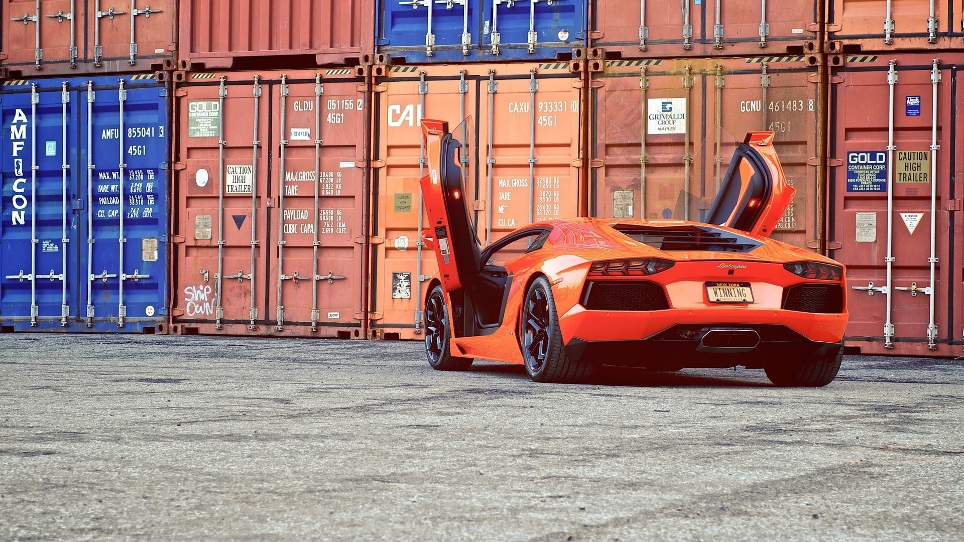 Orange Lamborghini Aventador parked by shipping containers HD Wallpaper
