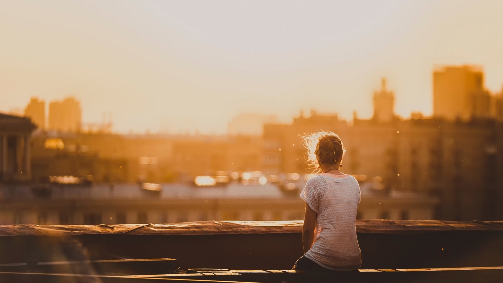 Woman sitting on a rooftop at sunset HD Wallpaper