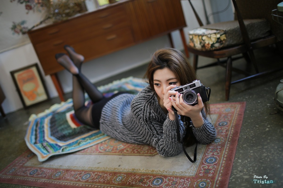Asian woman lying on rug holding camera HD Wallpaper