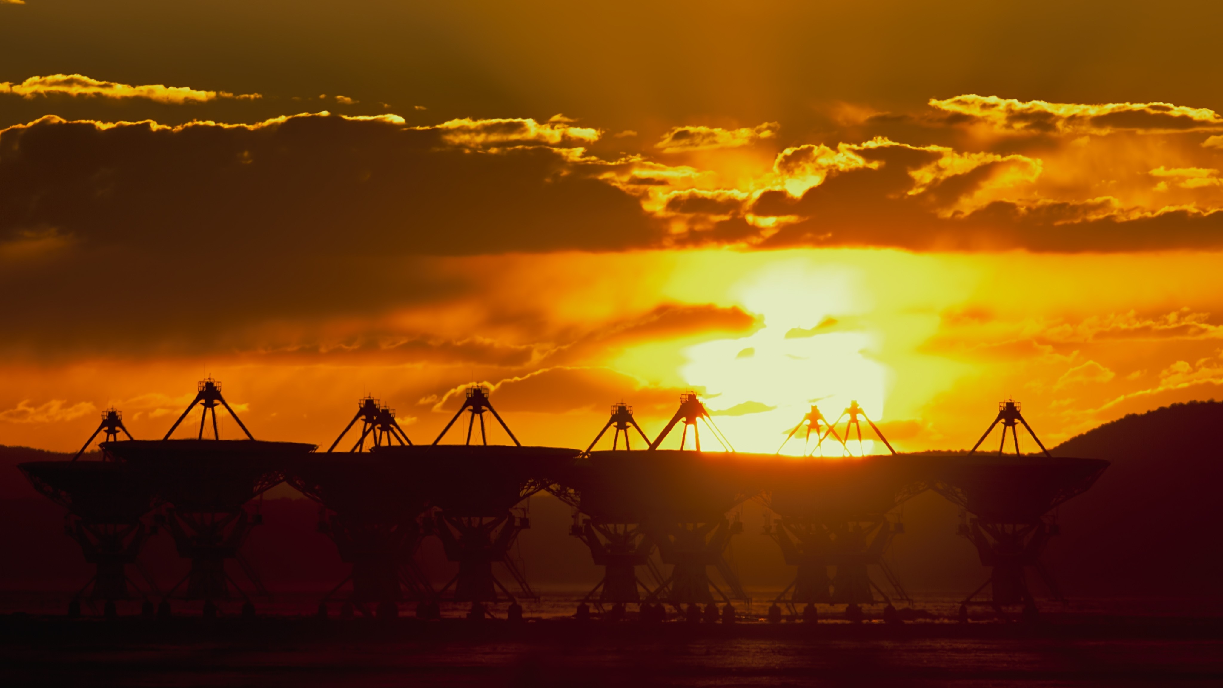 Radio telescopes silhouetted against a sunset HD Wallpaper