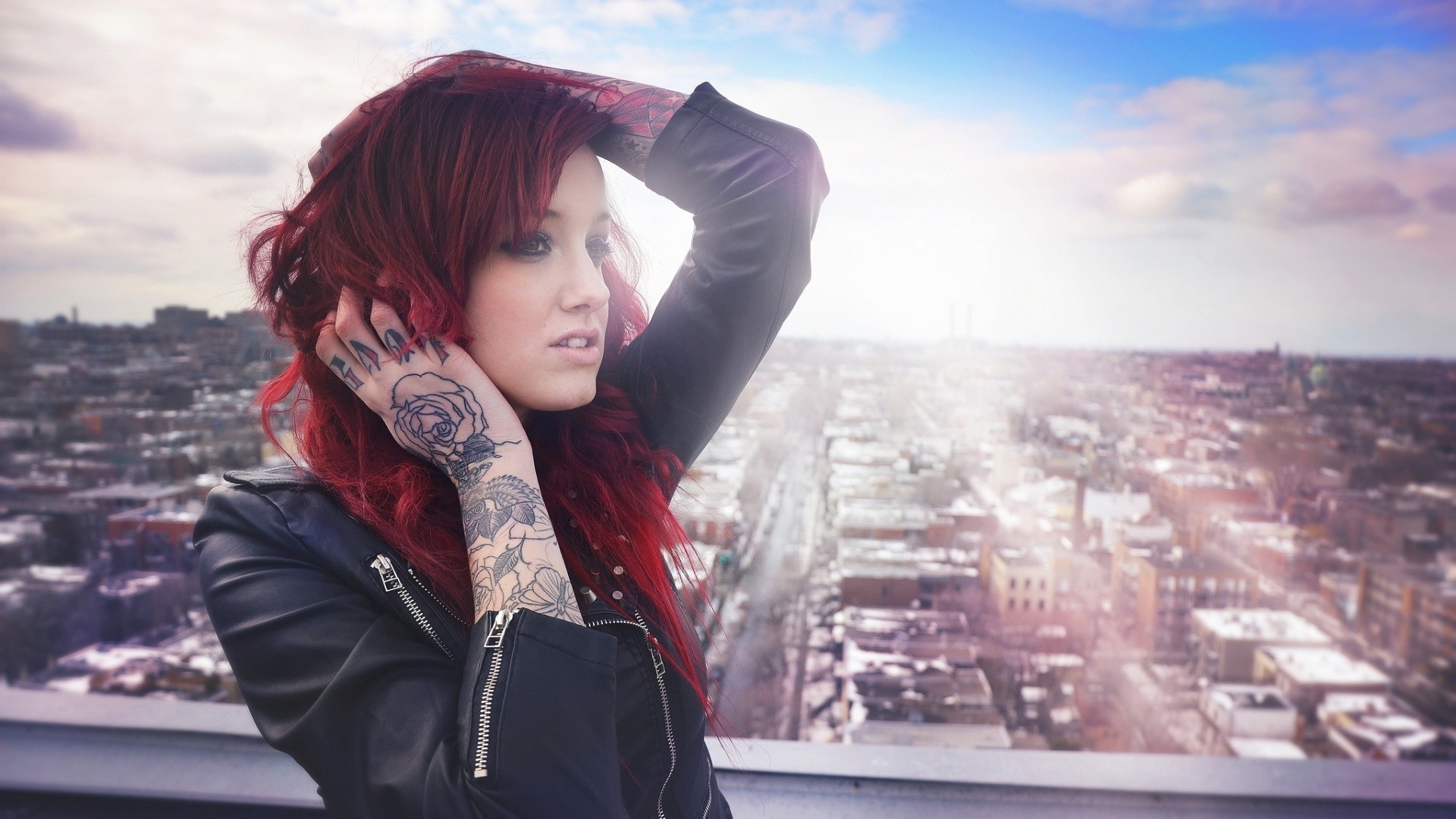 Tattooed redhead model posing on a rooftop overlooking city HD Wallpaper