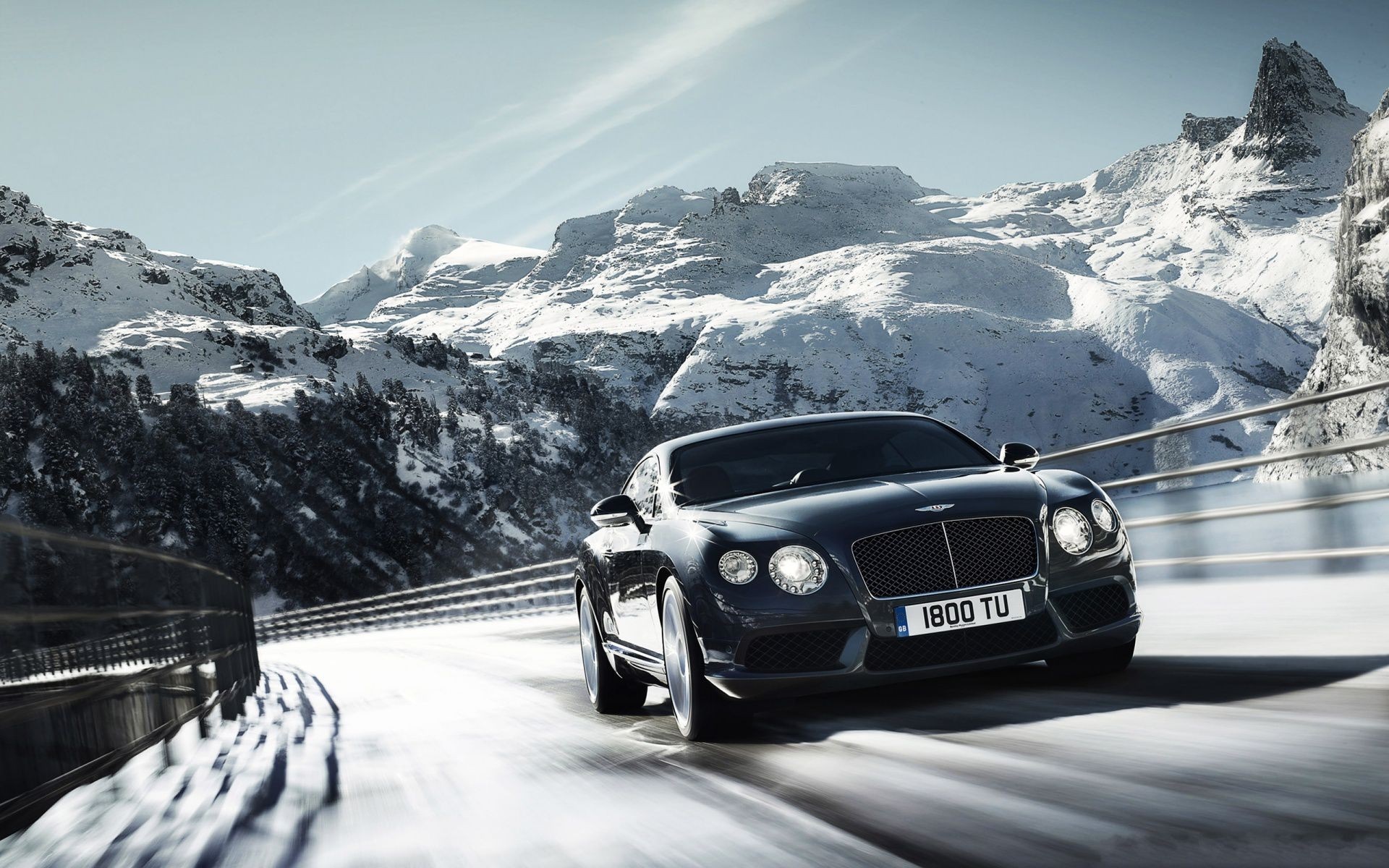 Bentley Continental GT driving on a snowy mountain road HD Wallpaper