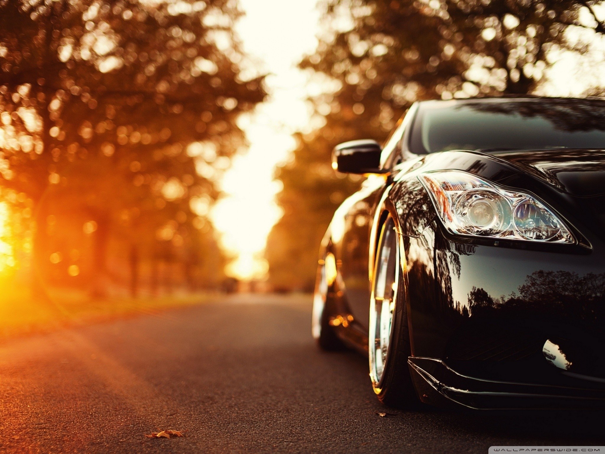 Black sports car on a road at sunset HD Wallpaper