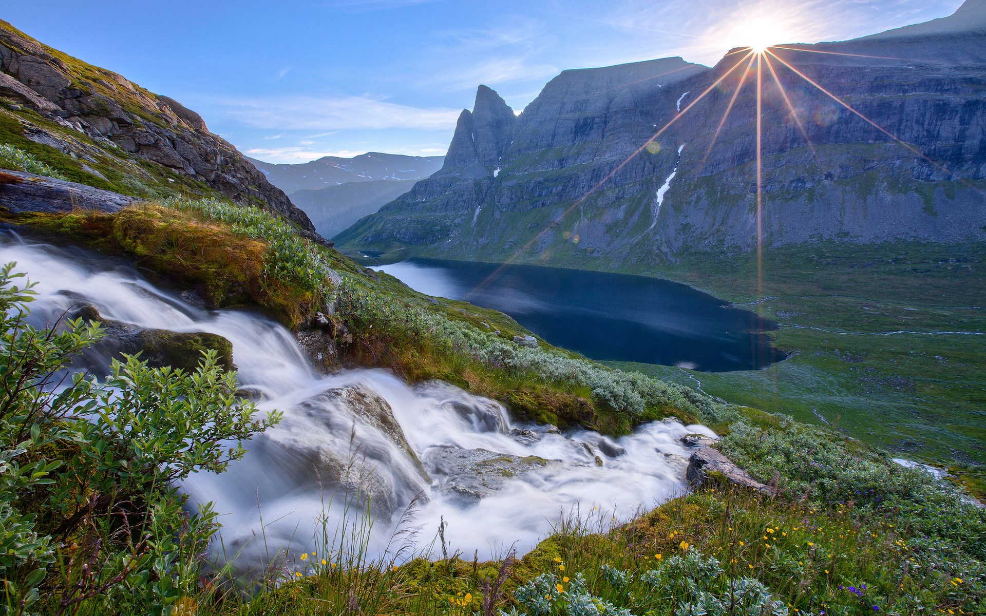 Waterfall flowing into a mountain lake at sunrise HD Wallpaper