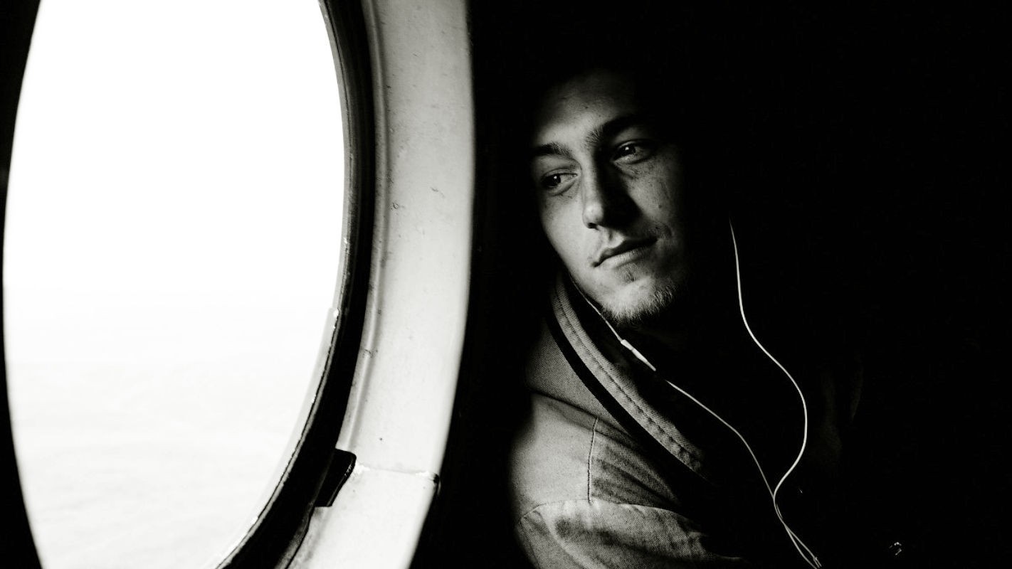 Man with headphones looking out a window HD Wallpaper