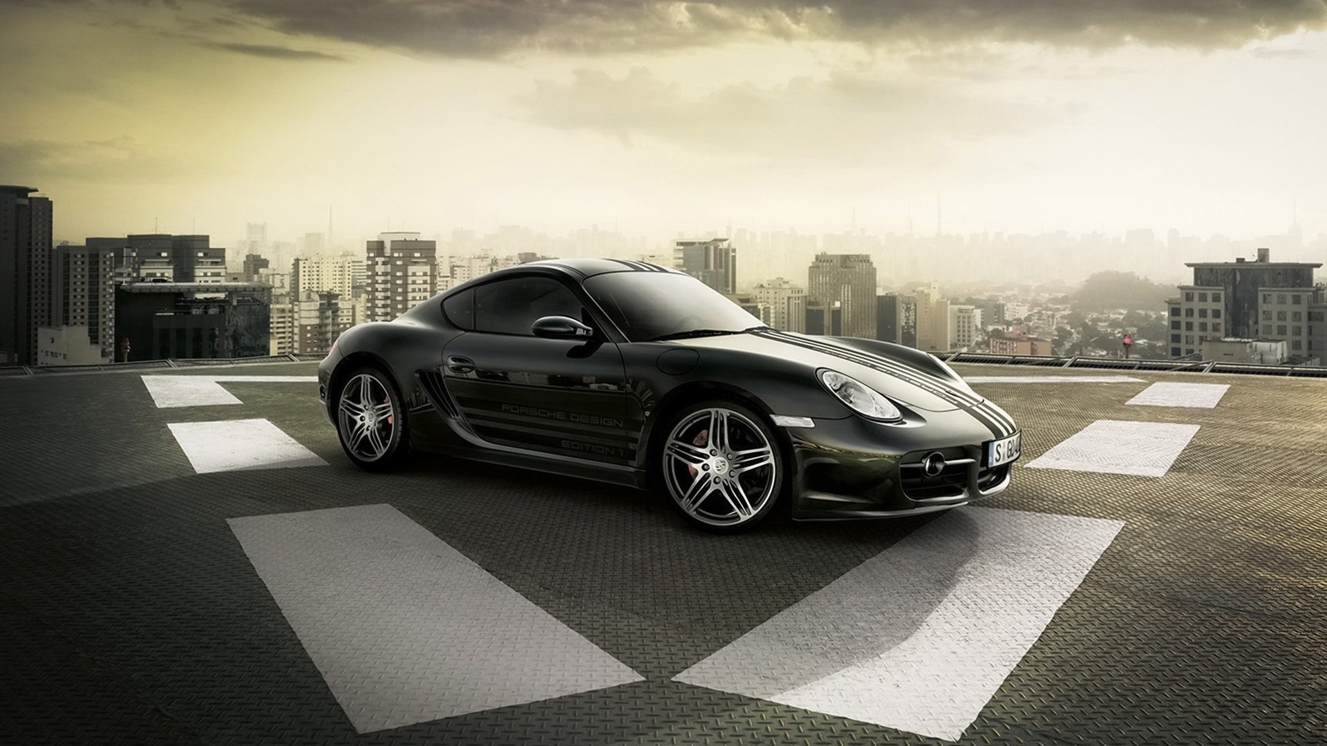 Black Porsche Cayman S on a helipad with city skyline HD Wallpaper