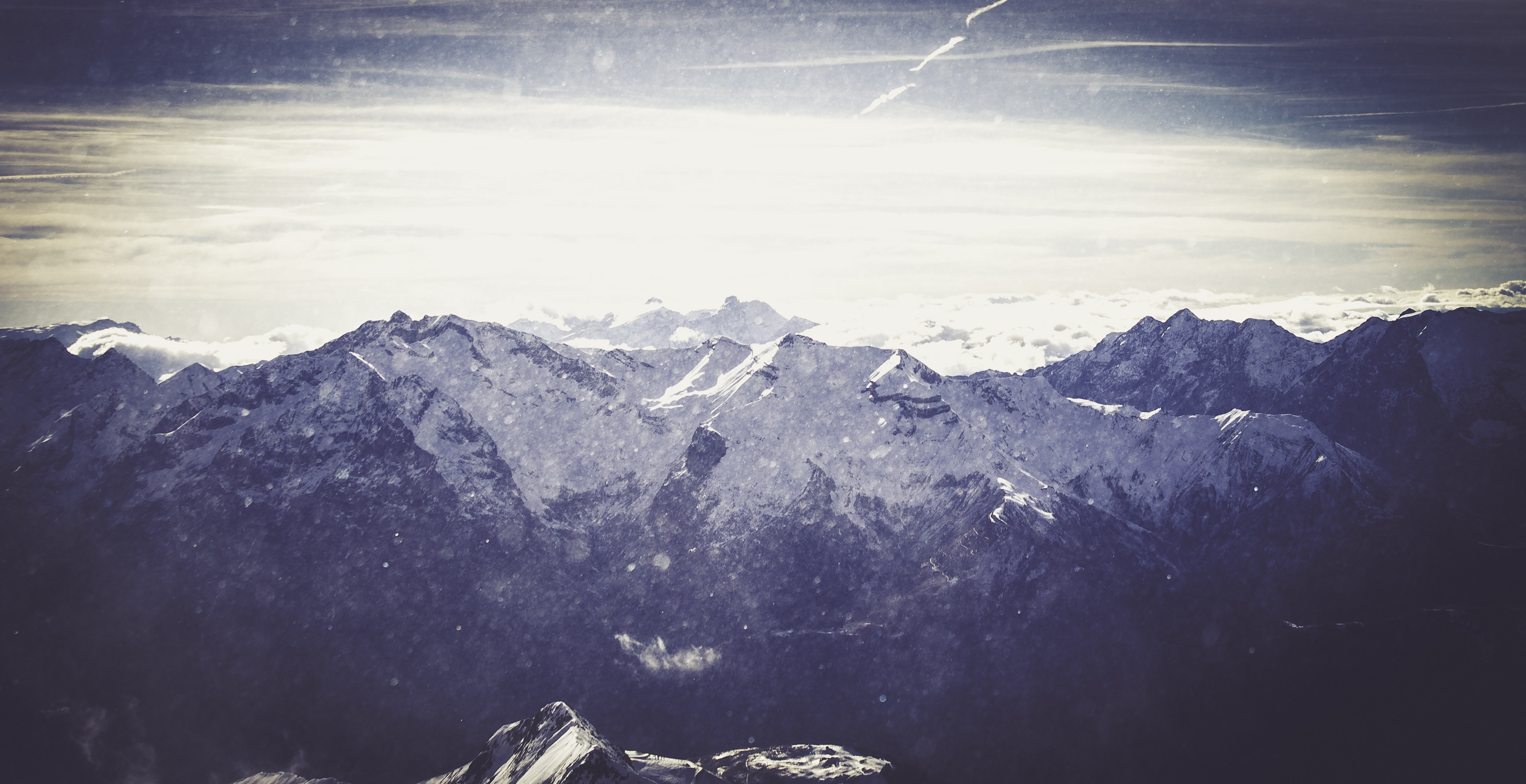 Snow-covered mountains under a bright sky HD Wallpaper