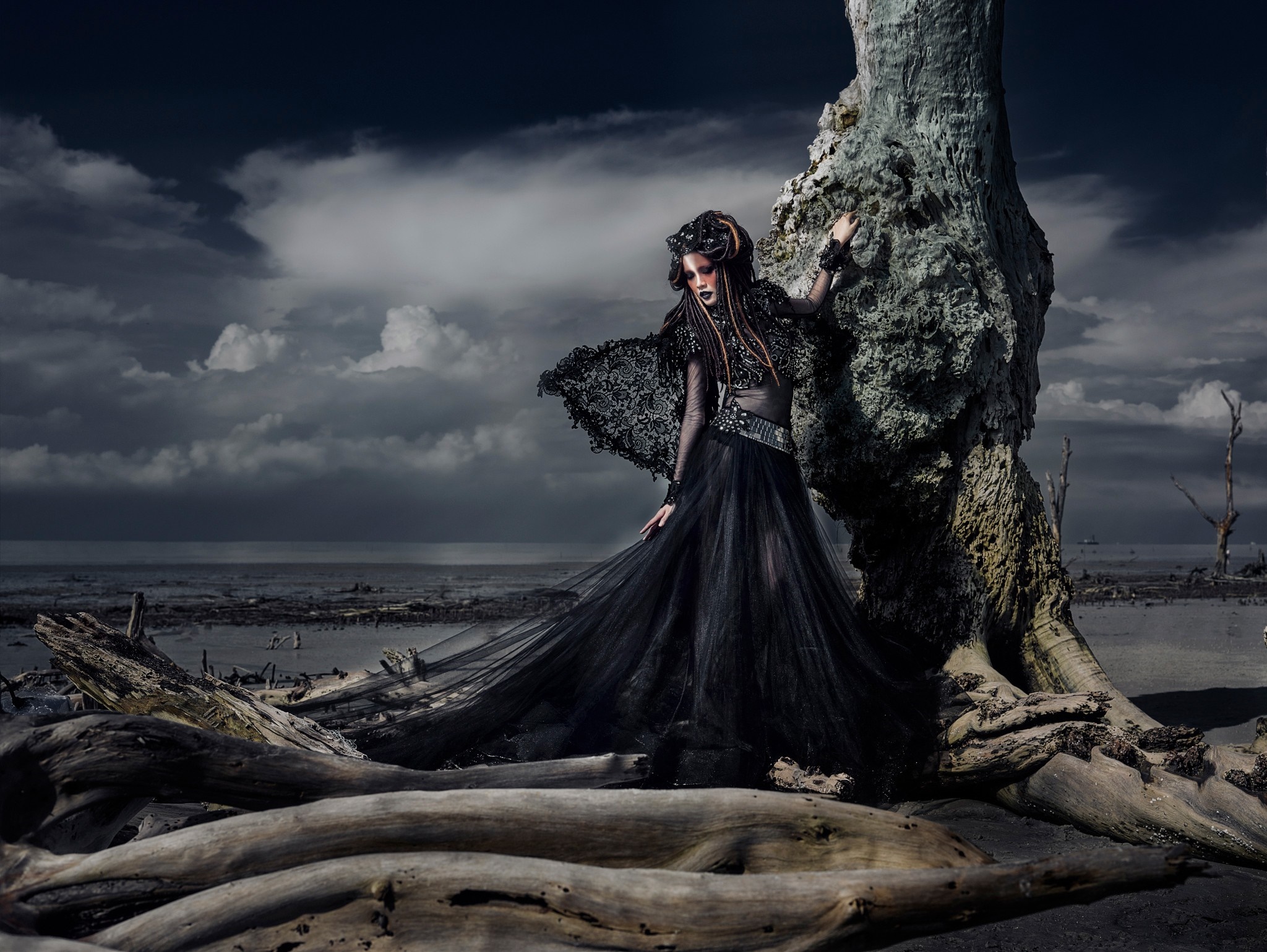 Model in black dress on a rocky coast HD Wallpaper