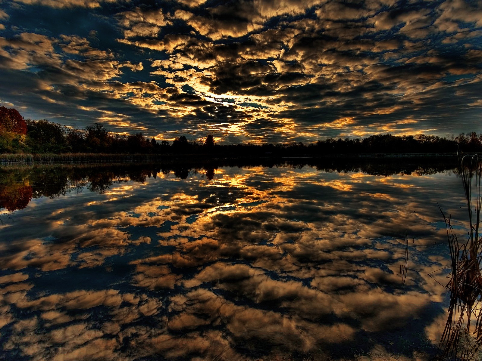 Sunset reflected on a lake with dramatic clouds HD Wallpaper