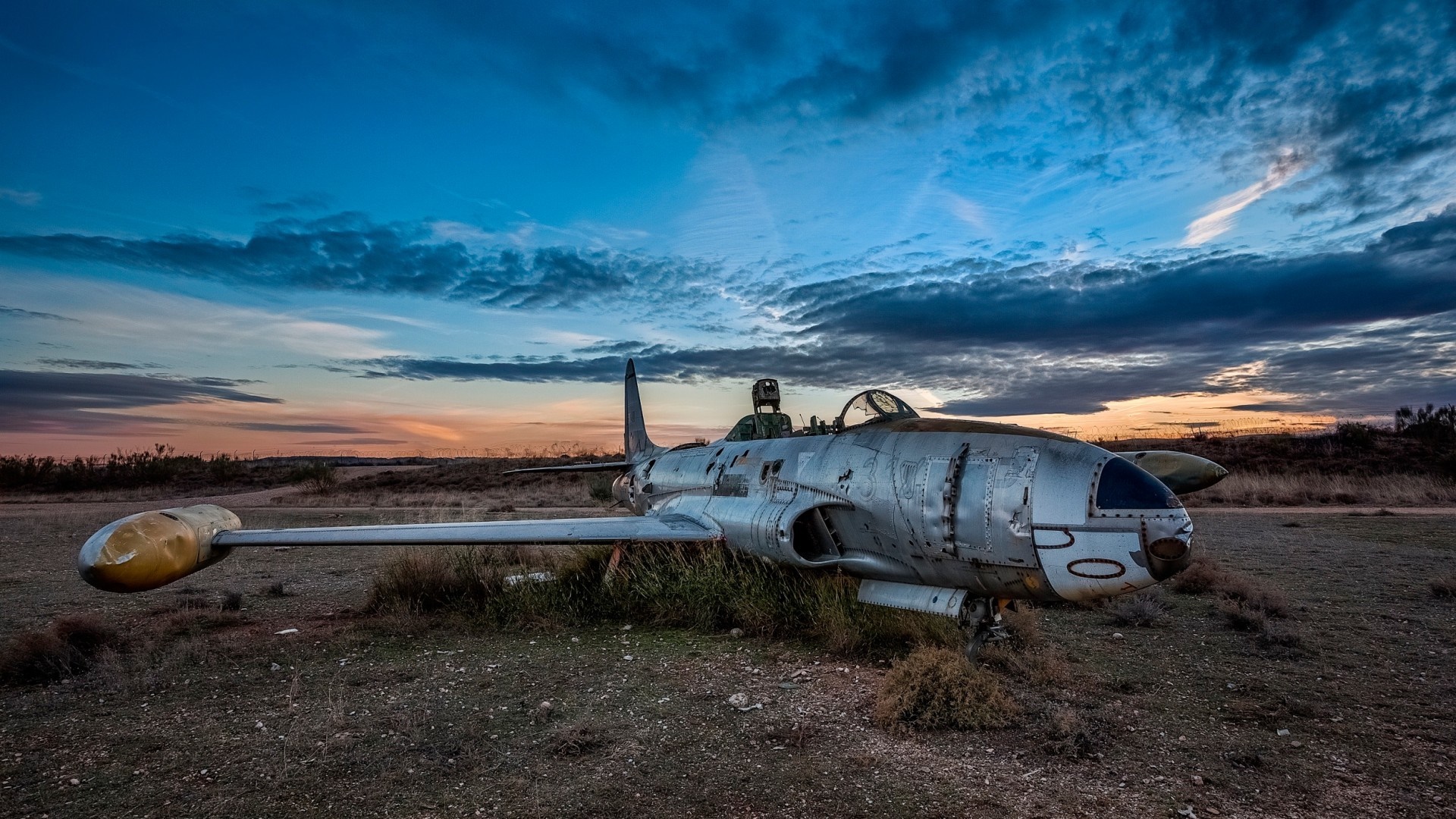 Abandoned Lockheed T-33 Shooting Star jet aircraft at sunset HD Wallpaper