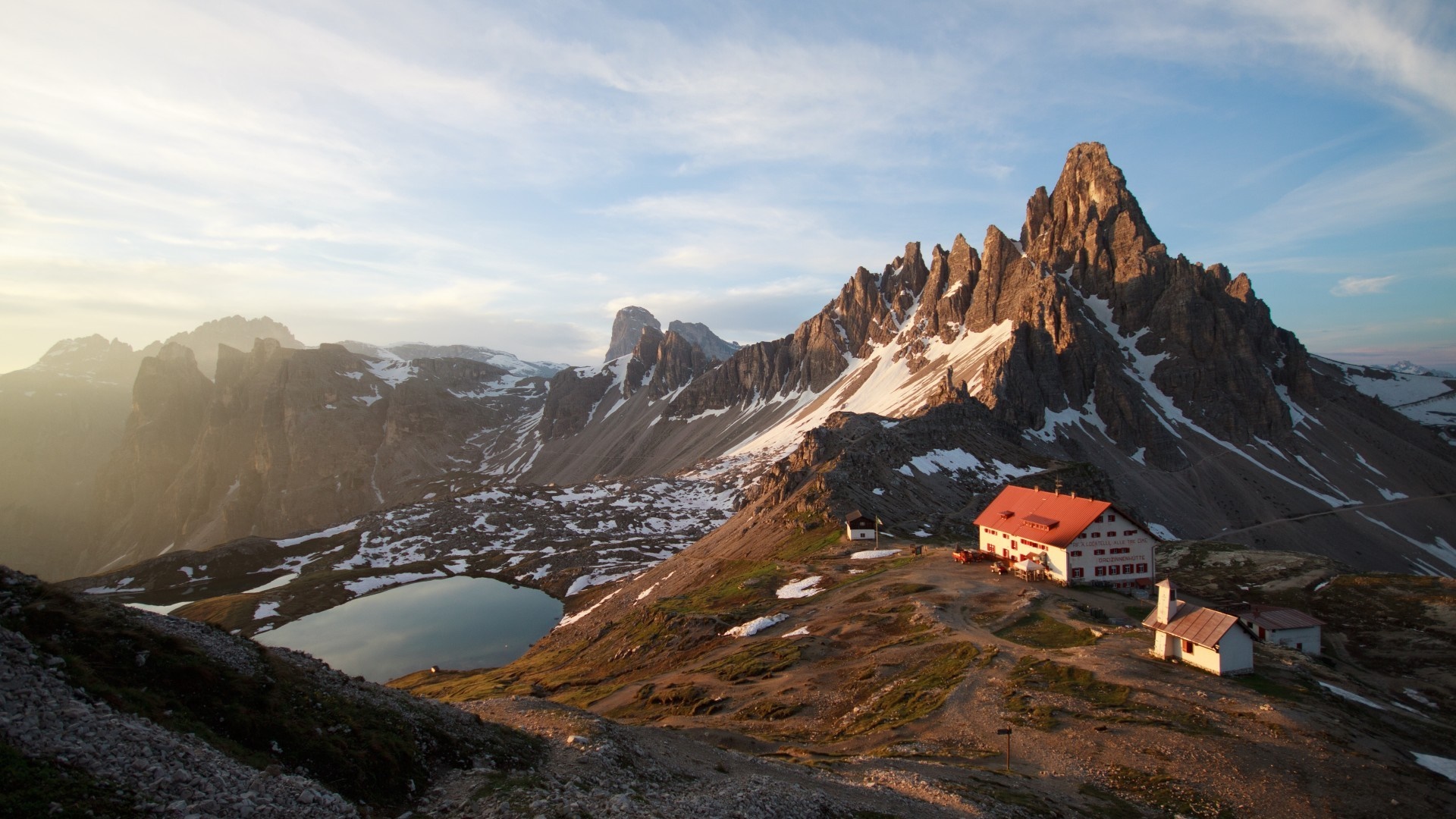 Mountain landscape with huts and lake in the Alps HD Wallpaper