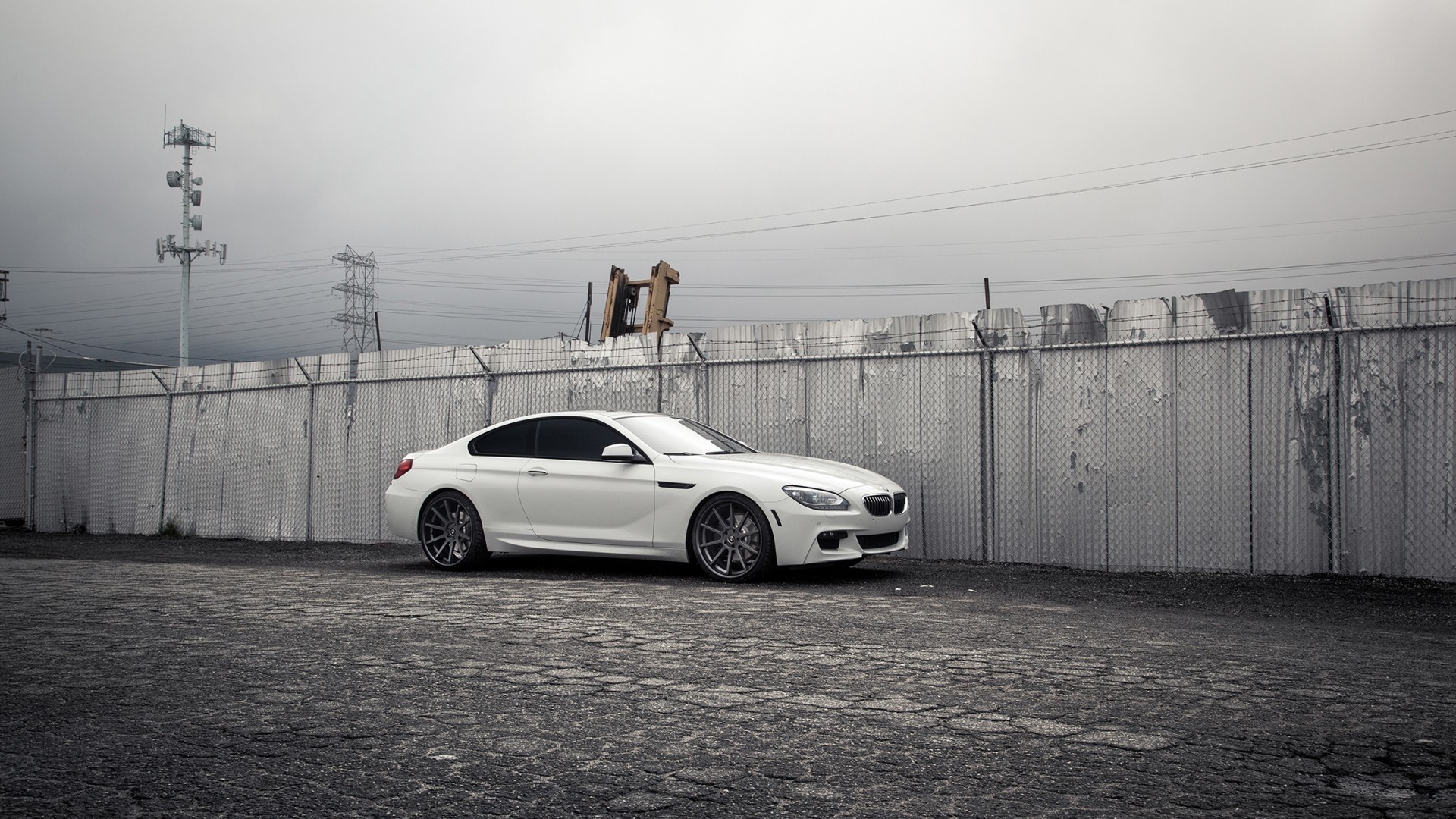 White BMW sports car parked by a chain-link fence HD Wallpaper