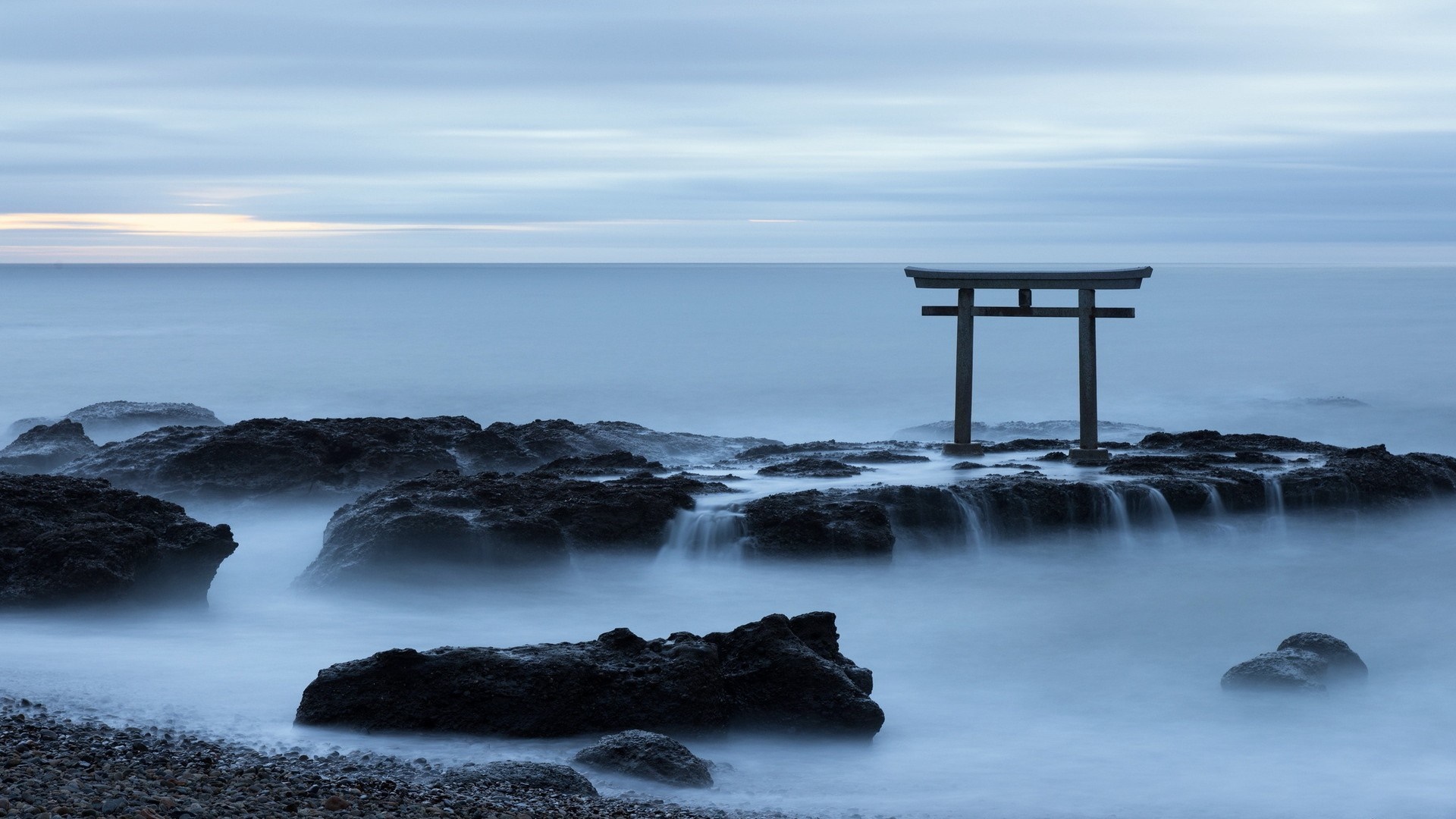 Torii gate on rocks in the sea at dawn HD Wallpaper
