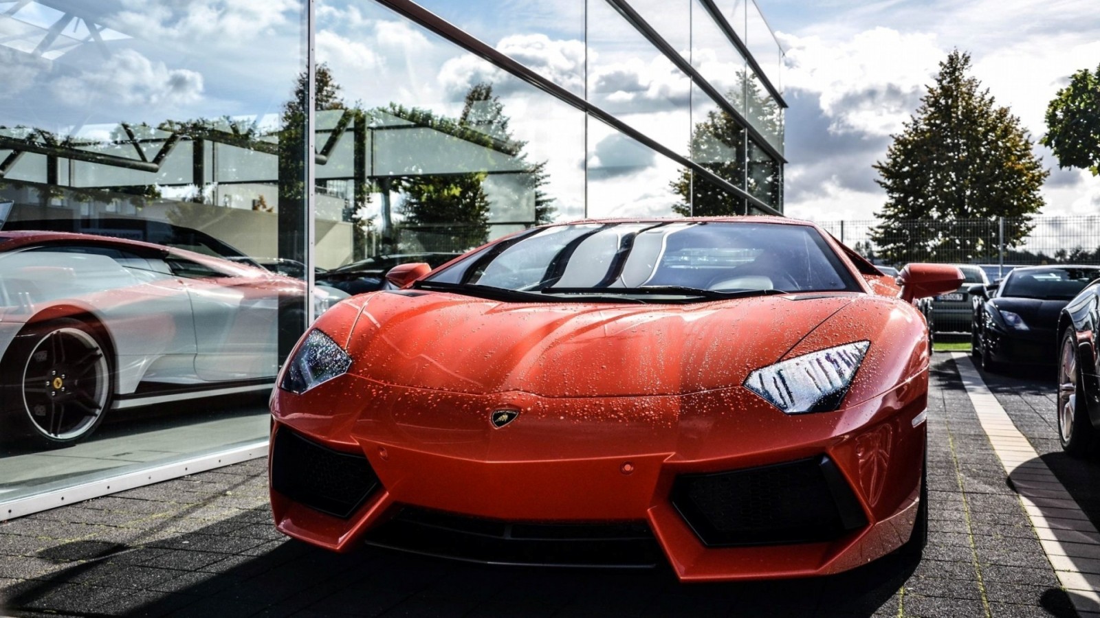 Orange Lamborghini Aventador parked outside a modern building HD Wallpaper