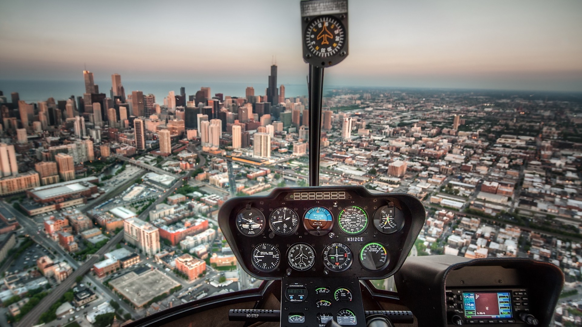 Helicopter cockpit view over Chicago cityscape at sunset HD Wallpaper