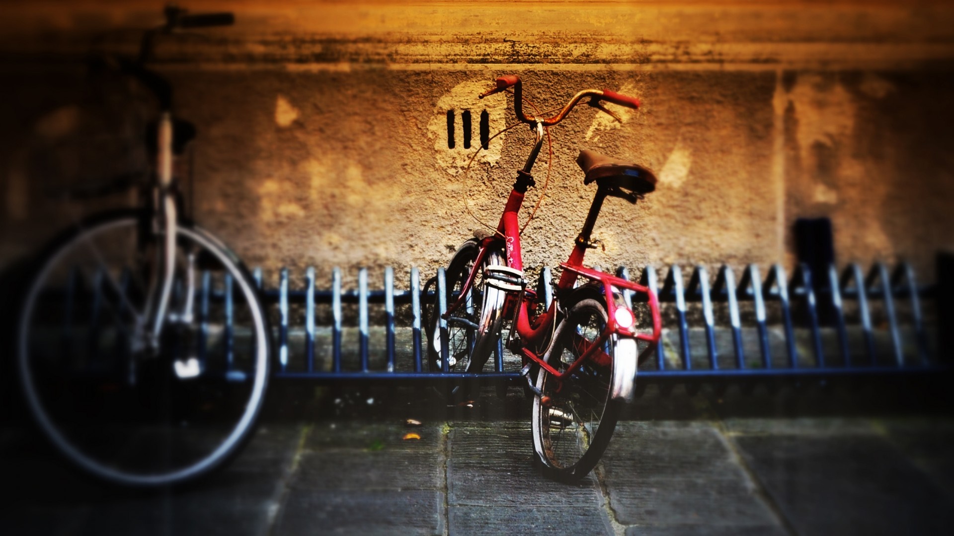 Two bicycles parked at a rack at night HD Wallpaper