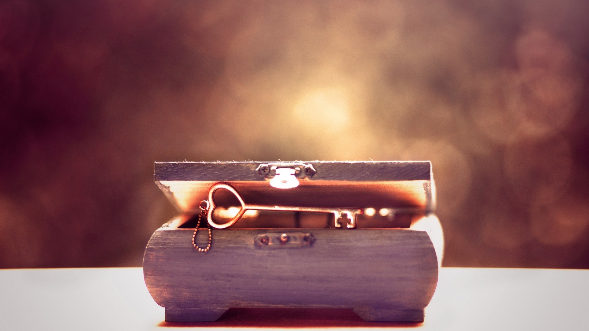 A heart-shaped key in an open wooden chest HD Wallpaper