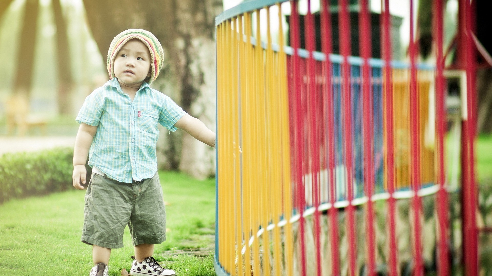 Child in a hat and shirt at a playground HD Wallpaper