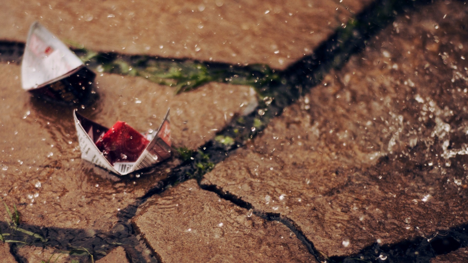 Paper boats floating in rain on pavement HD Wallpaper