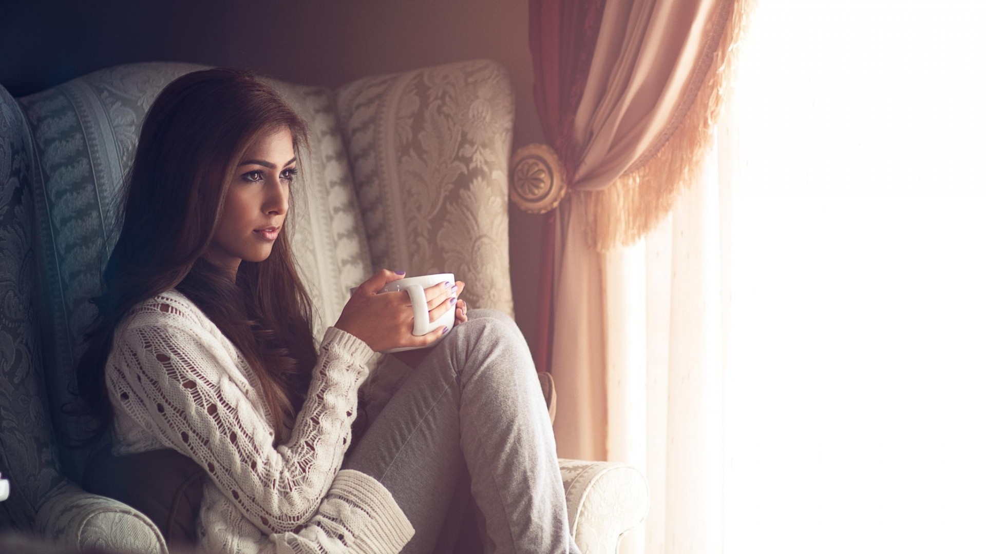 Woman holding a mug in a chair HD Wallpaper