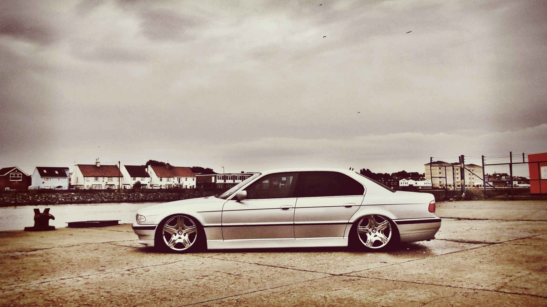 Silver BMW 7 Series sedan parked by the water HD Wallpaper