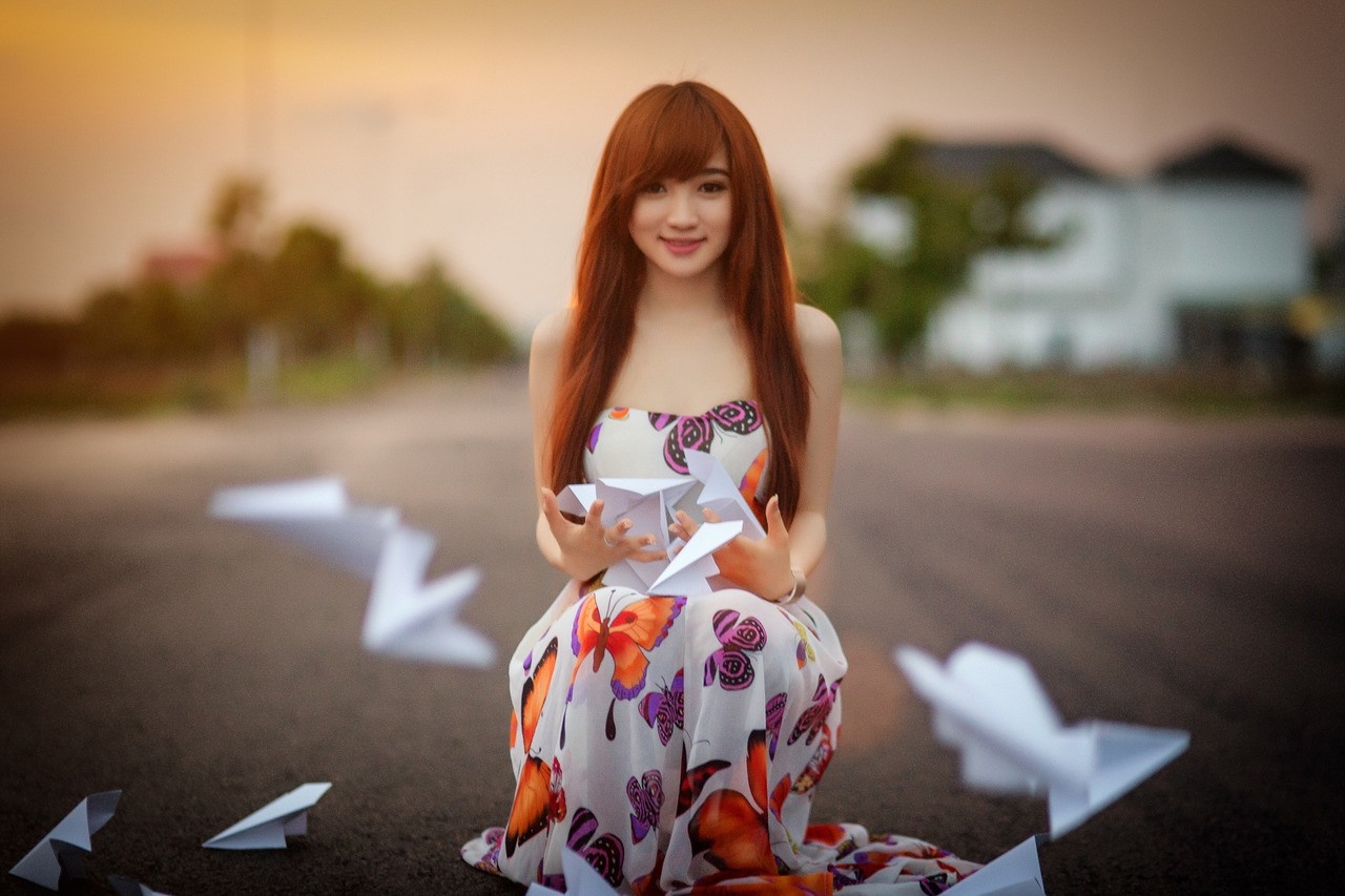 Young woman with red hair holding paper planes HD Wallpaper