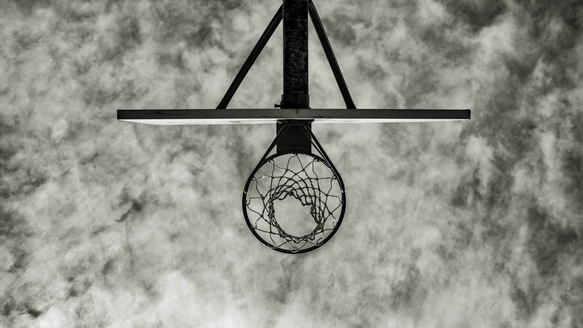 Basketball hoop viewed from below against cloudy sky HD Wallpaper