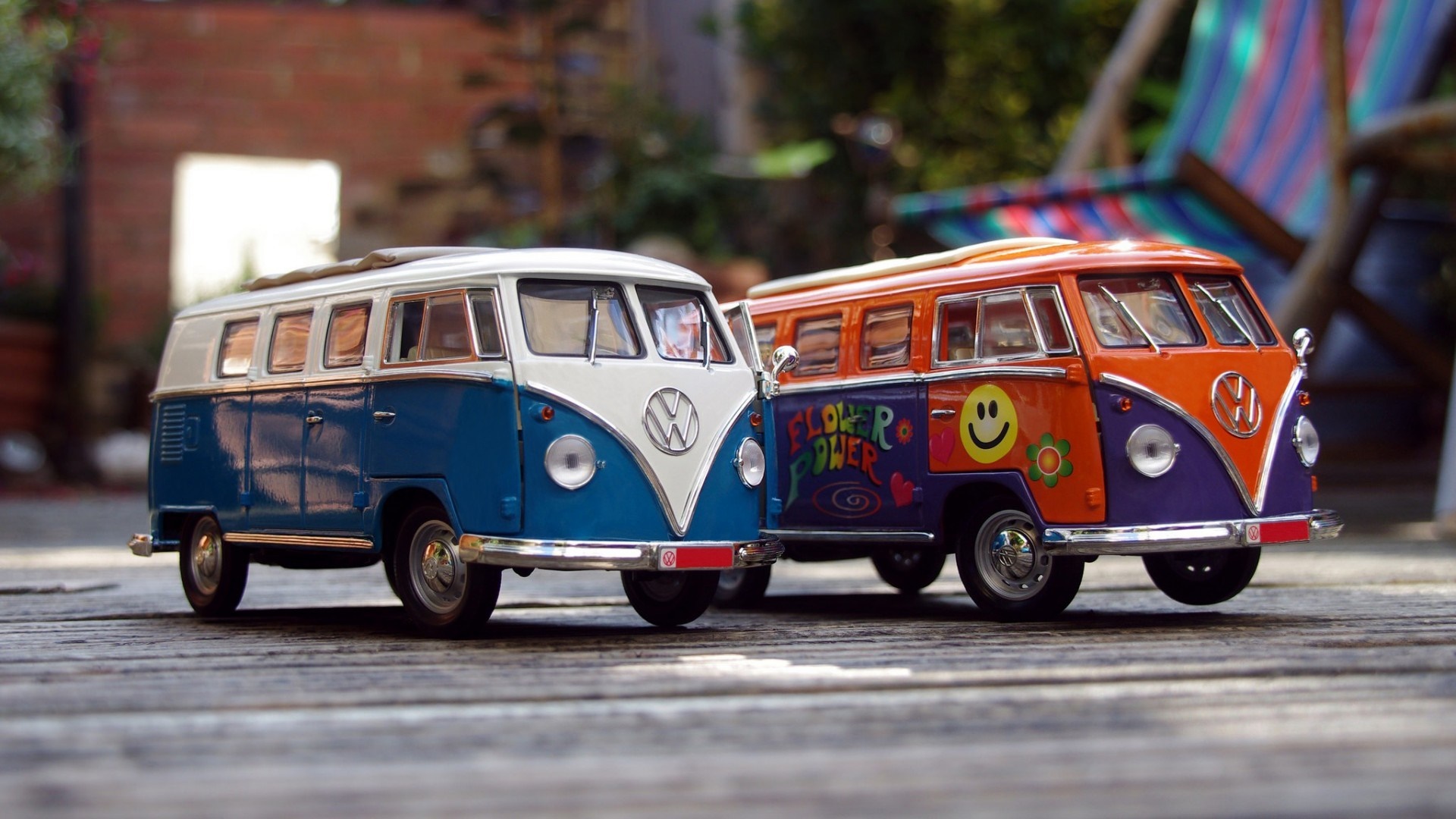 Two Volkswagen Combi toy vans on a wooden surface HD Wallpaper