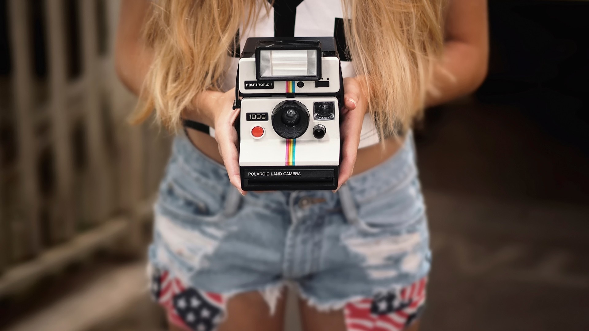Woman holding a Polaroid Land Camera 1000 HD Wallpaper